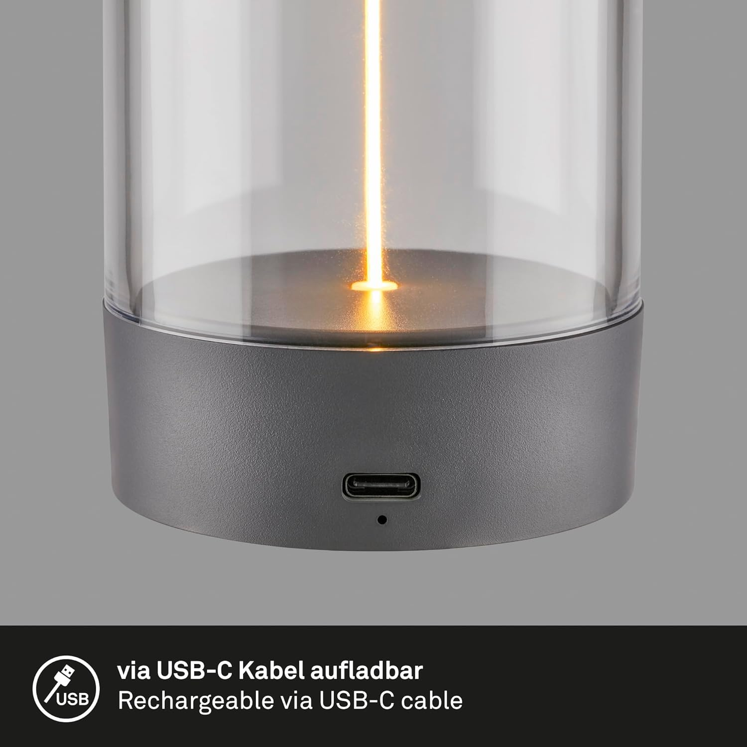 Eine moderne graue Lampe mit Glasschirm, beleuchtet von einer warmen LED. Mit USB-C-Anschluss.
