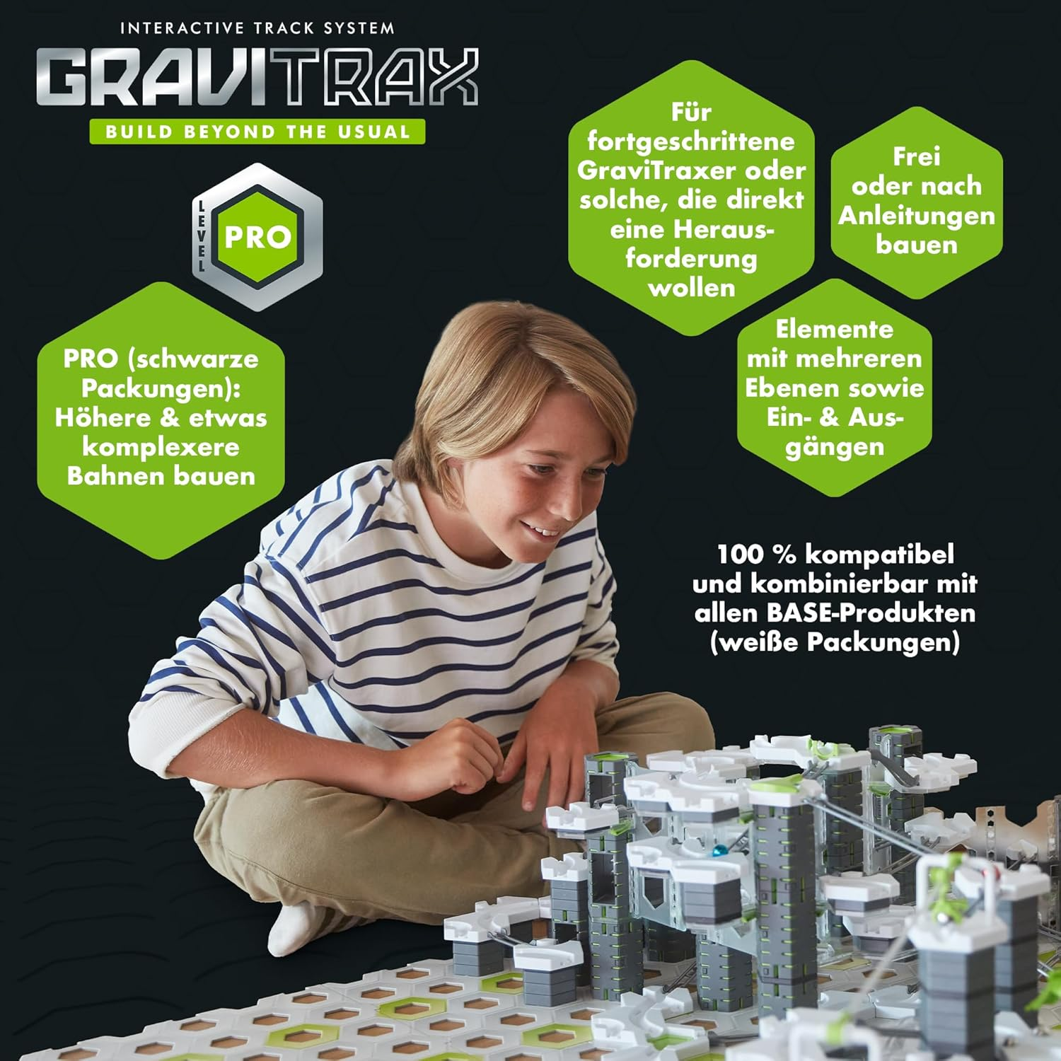 Junge baut GraviTrax-Bahn mit grauen und grünen Elementen. Text über PRO-Version.