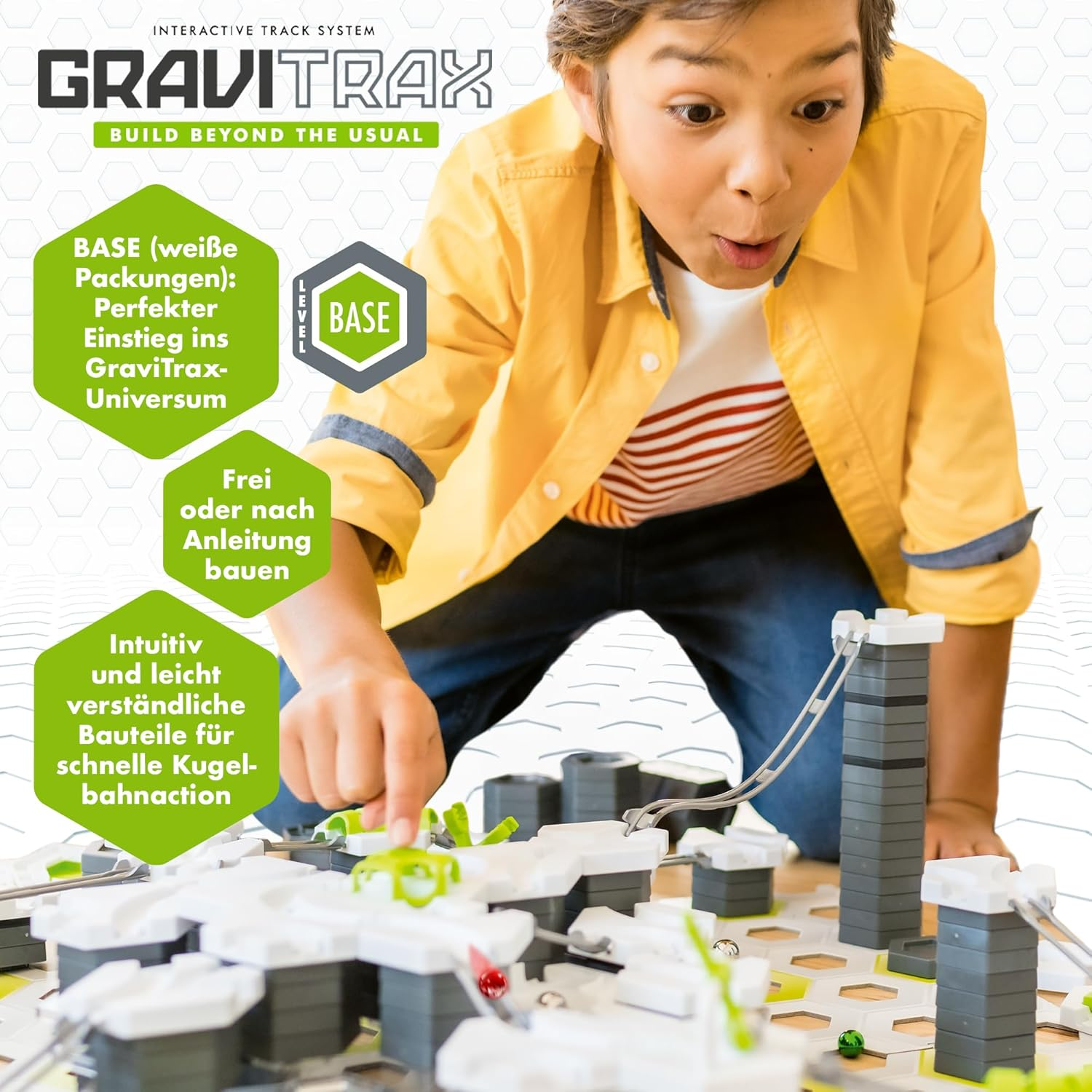 Ein Junge spielt mit Gravitrax, einem interaktiven Schienensystem. Bunte Bausteine und Kugeln sind zu sehen.