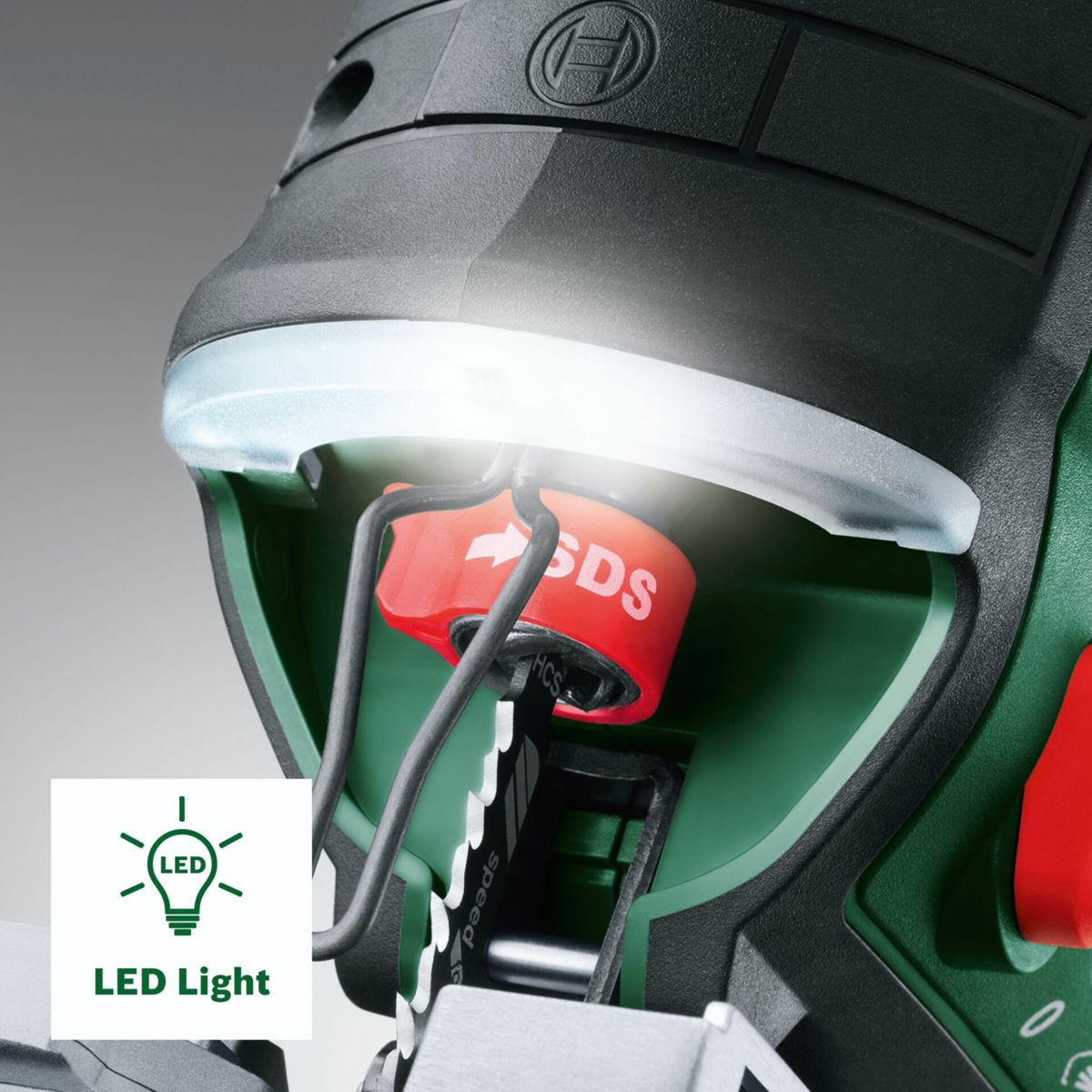Nahaufnahme einer grünen Stichsäge mit leuchtender LED-Lampe und rotem SDS-Hebel.