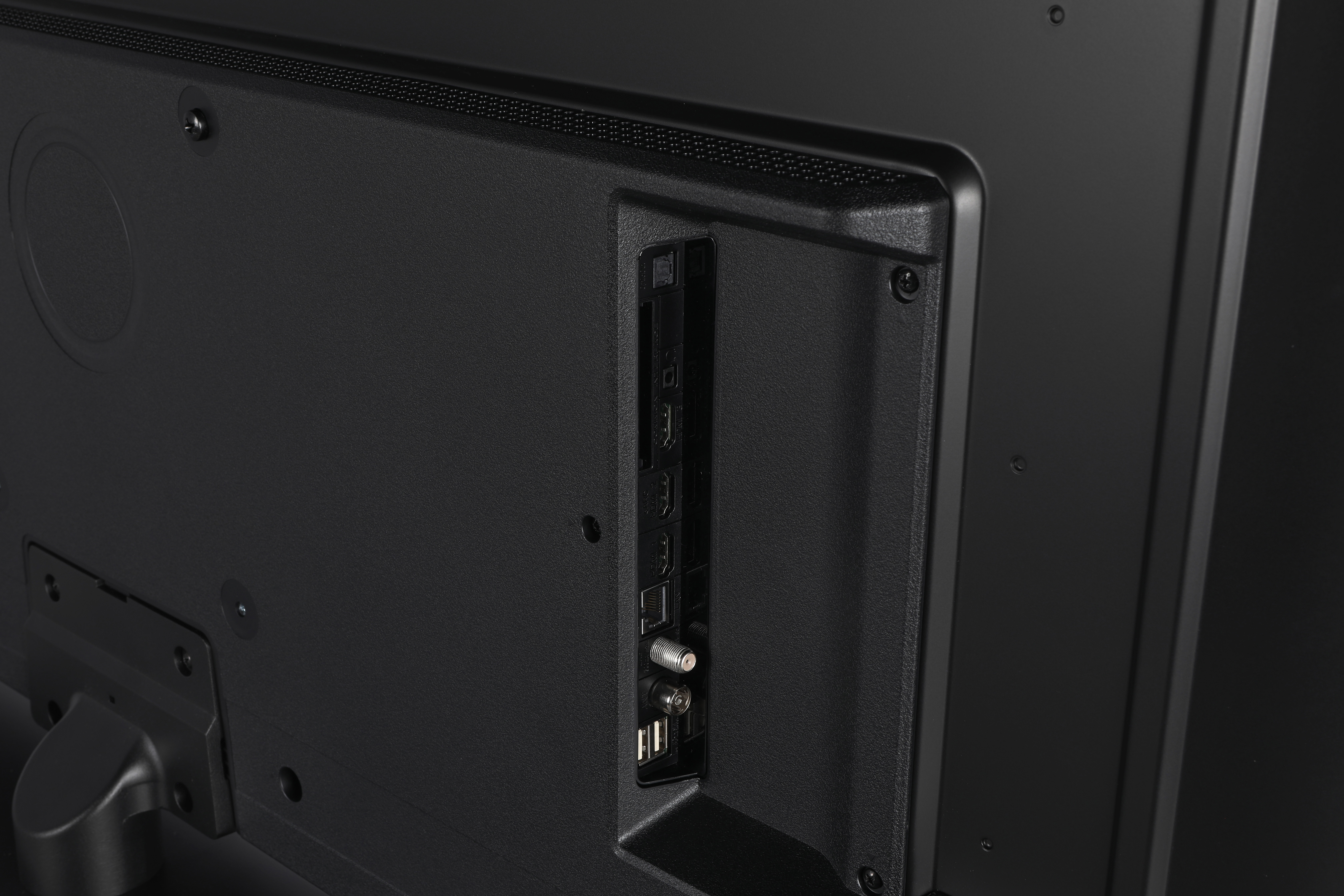 Rückseite eines schwarzen Fernsehers mit Anschlüssen wie HDMI und USB.