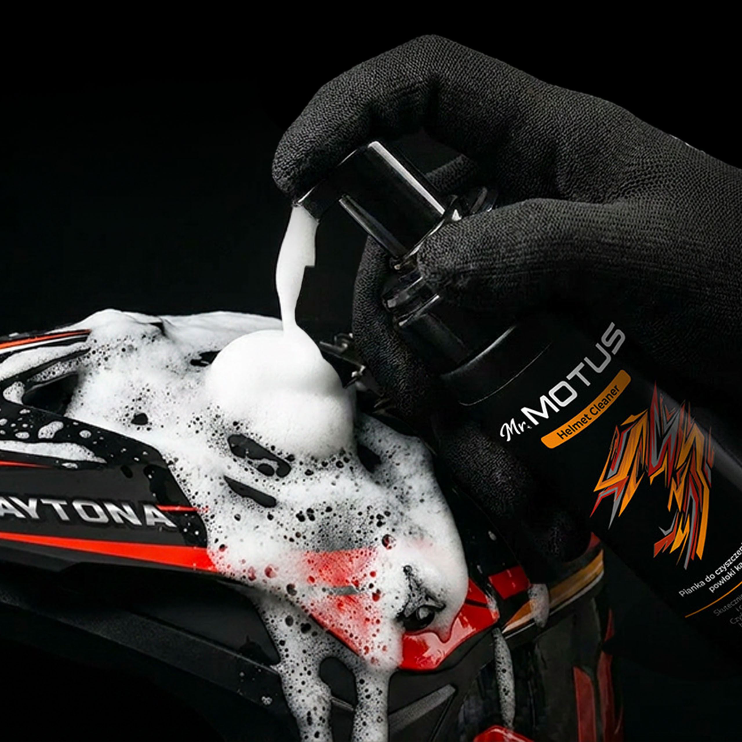 Mano enguantada negra rocía espuma sobre un casco negro y rojo.