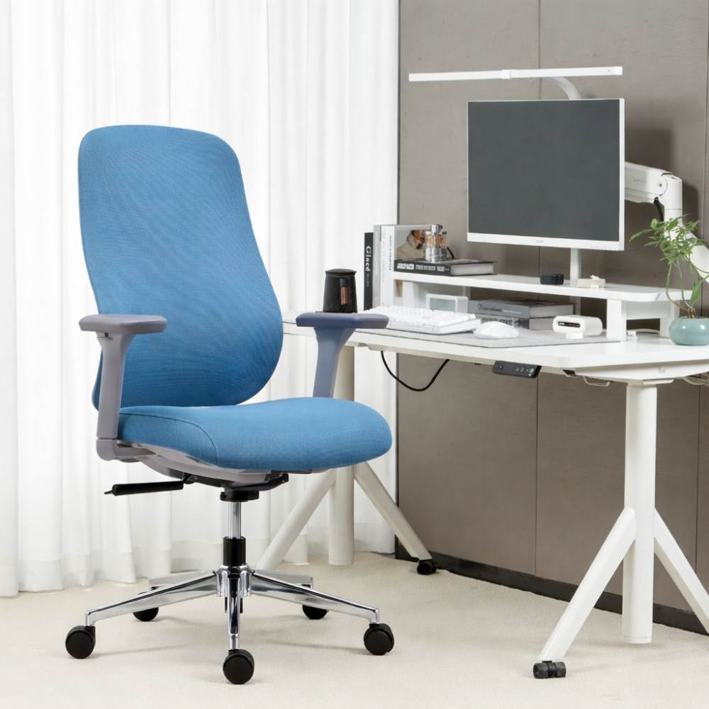 Sedia ergonomica blu accanto a una scrivania bianca con computer e monitor.