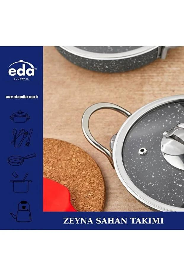 Ahşap zemin üzerinde cam kapaklı bir tencere seti.