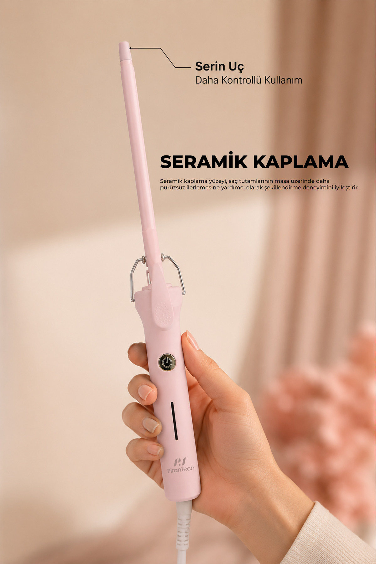 Bir el, seramik kaplamalı pembe bir saç maşası tutuyor.