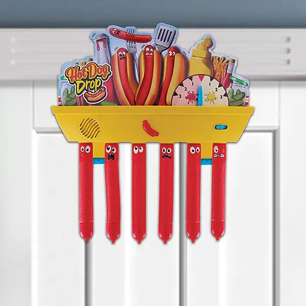 Gra Hot Dog Drop z żółtą platformą i zwisającymi czerwonymi patyczkami w kształcie parówek.