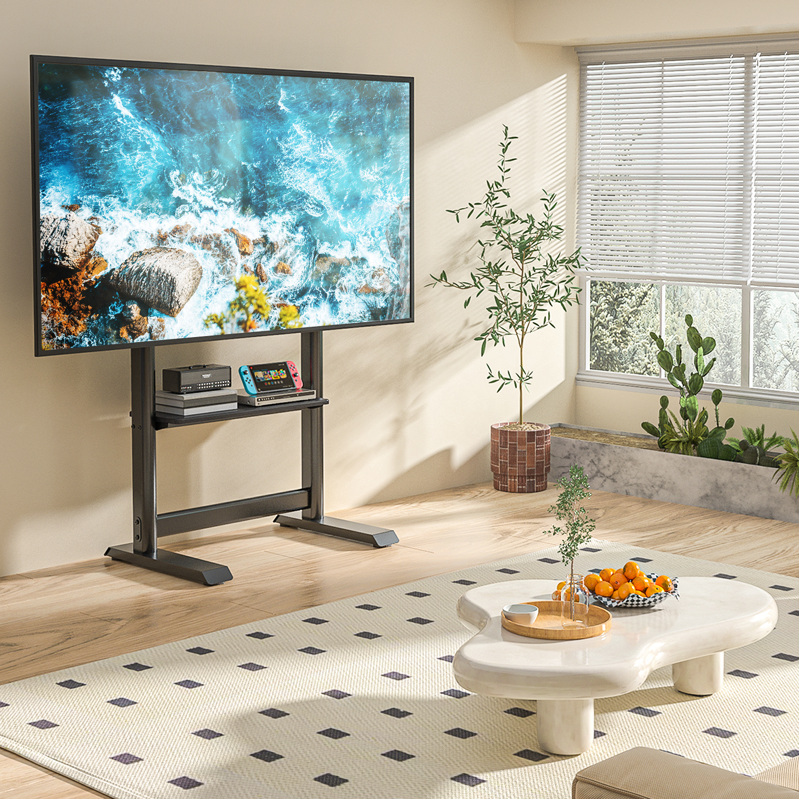 Ein moderner Wohnraum mit einem TV auf einem Ständer, Spielkonsolen und einer Obstschale.