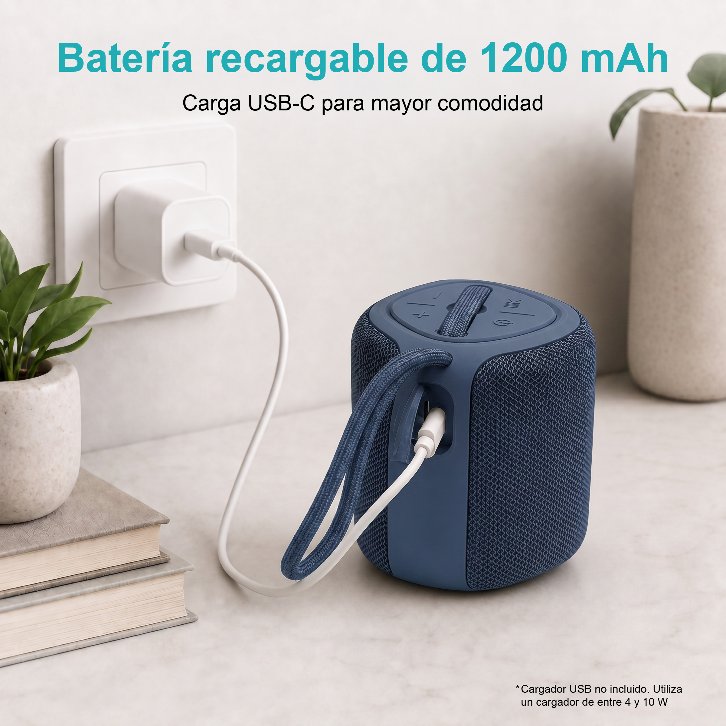 Altoparlante blu in carica via USB-C, accanto a libri e una pianta.