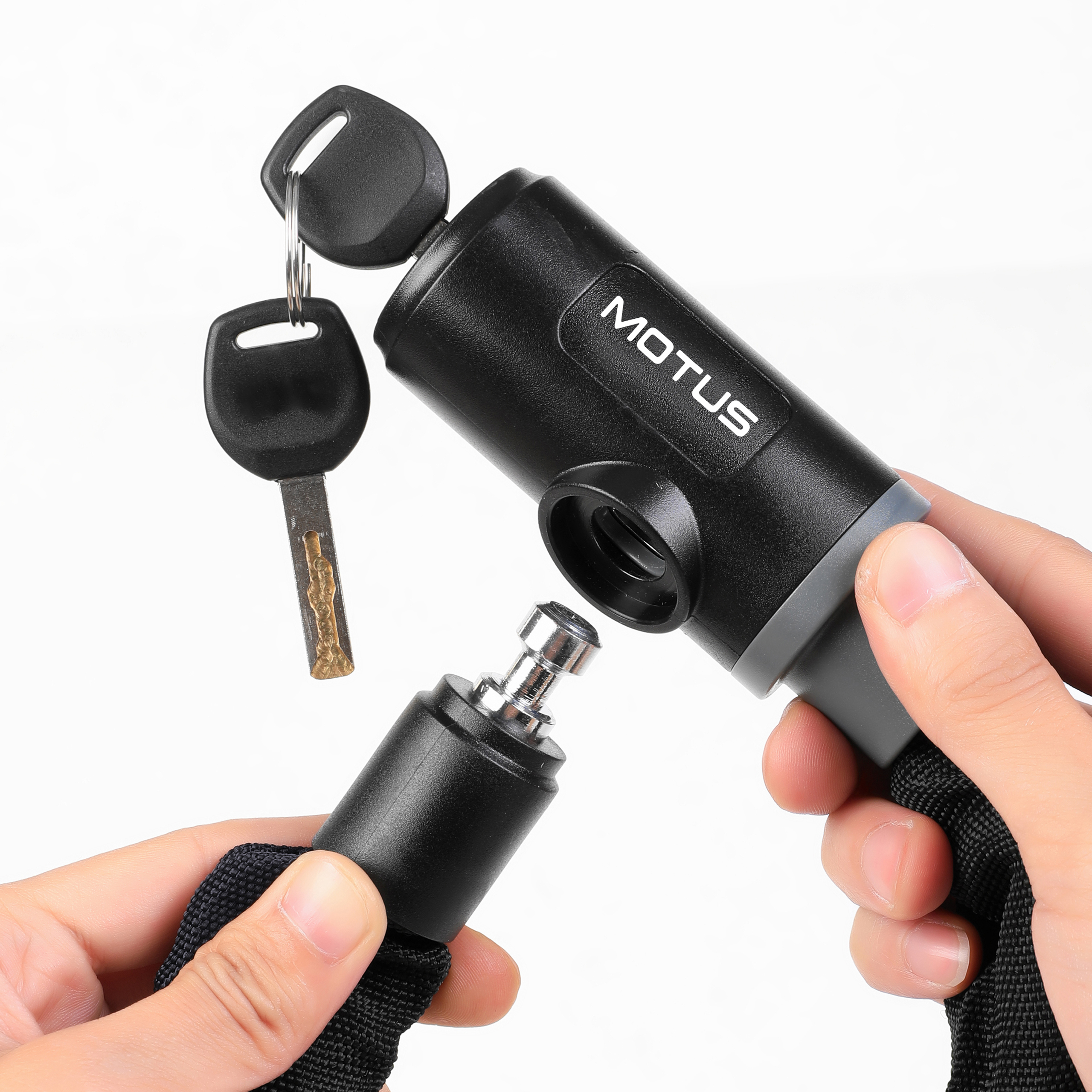 Una mano tiene un lucchetto per bicicletta nero con due chiavi. Una chiave è inserita nel lucchetto.