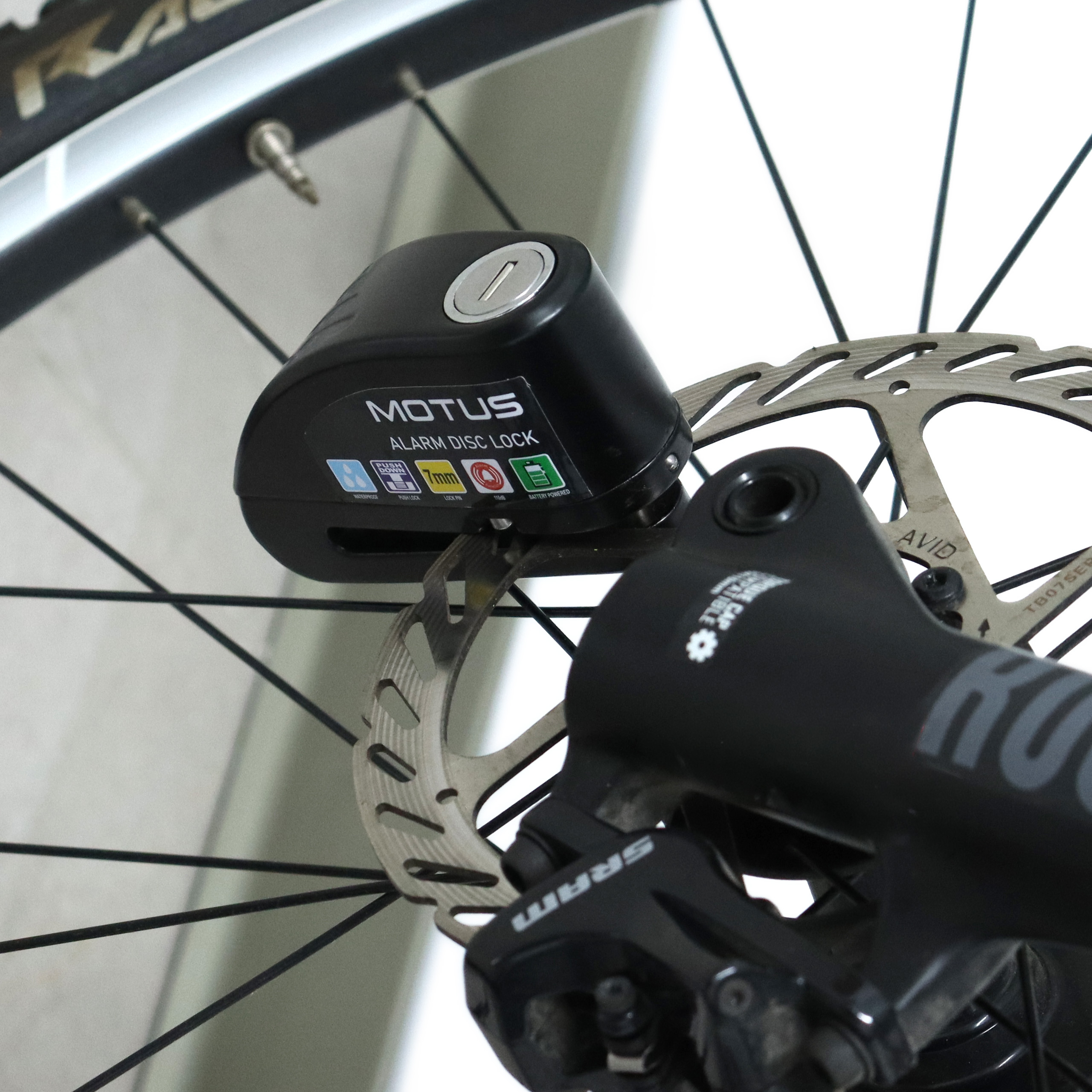 Lucchetto nero Motus con allarme a disco su disco freno e ruota di bicicletta.