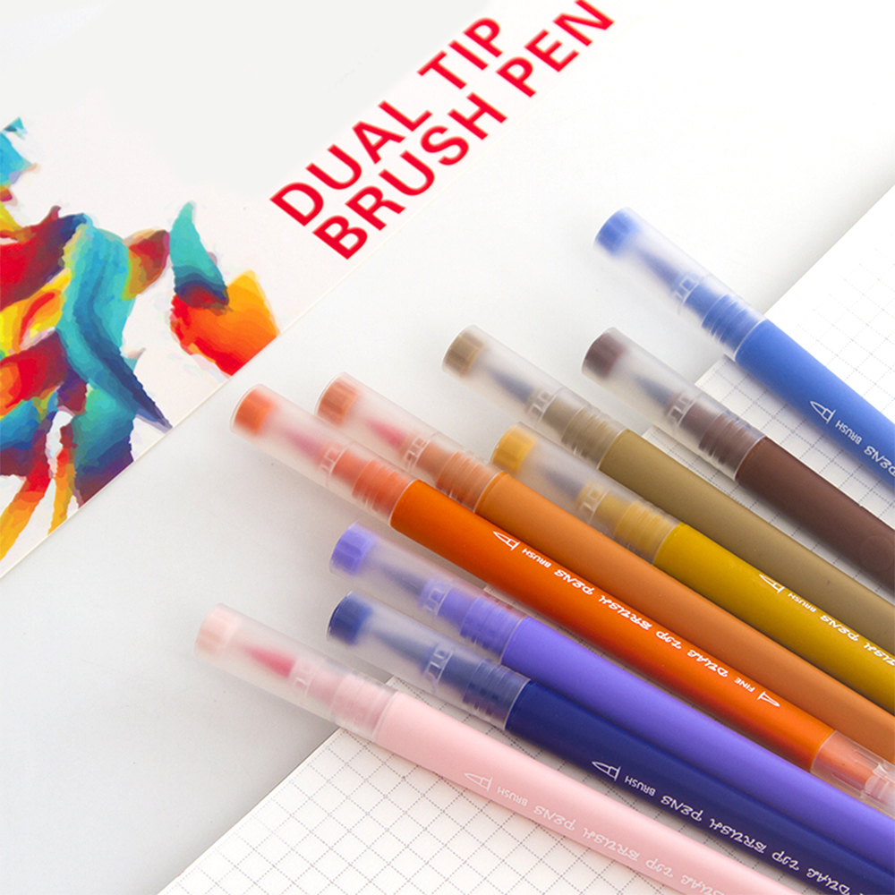 Pennarelli colorati su un quaderno. Il testo dice DUAL TIP BRUSH PEN.