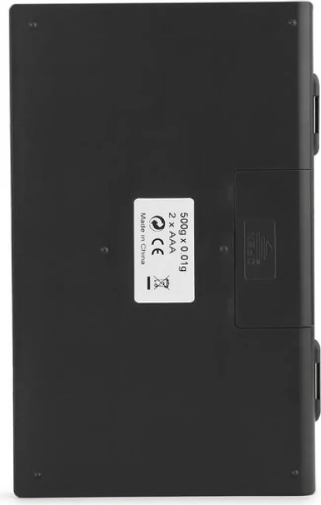 Rückseite einer schwarzen Digitalwaage mit Beschriftung und Batteriefach.