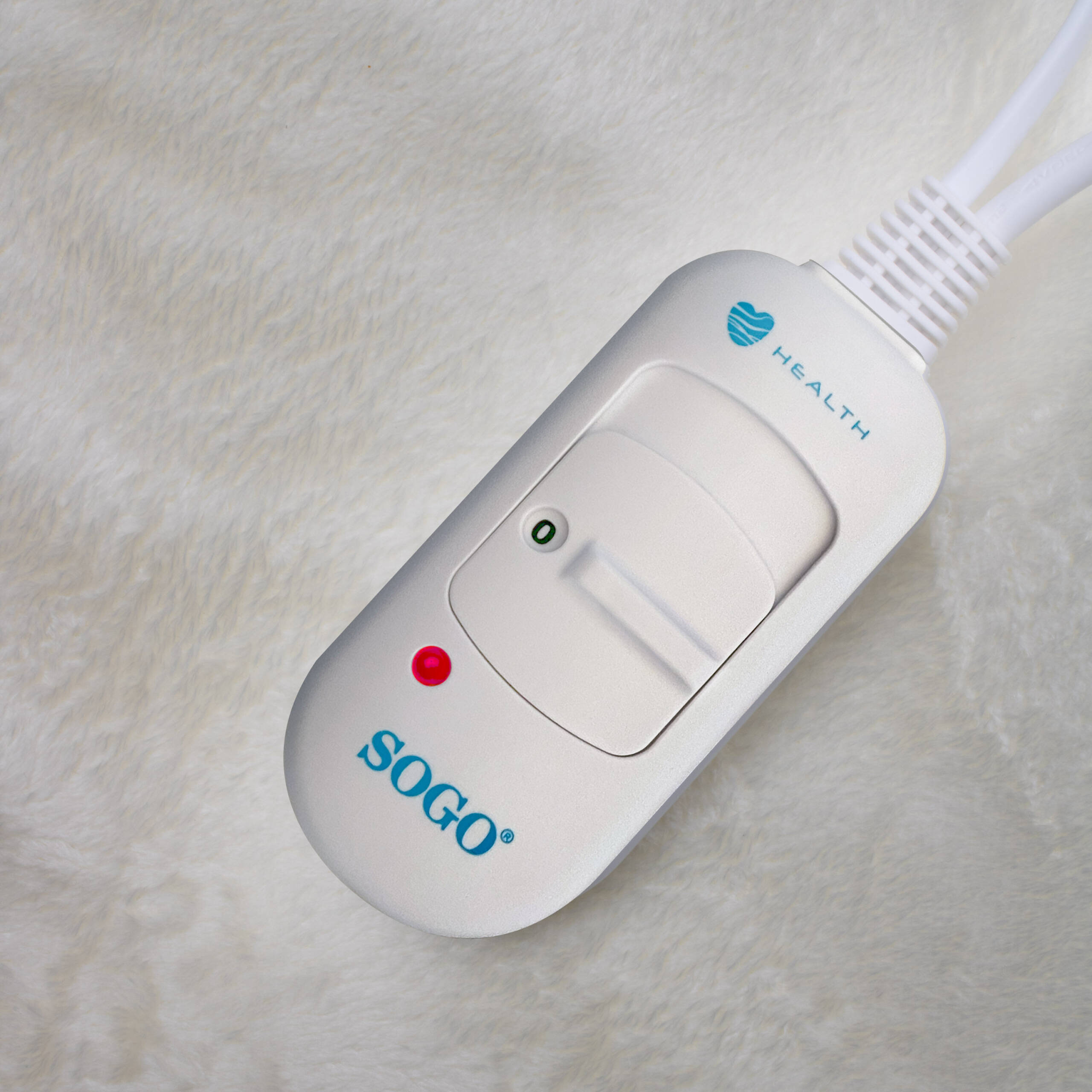 Un controller bianco Sogo per coperta elettrica con luce rossa e cursore su tessuto.