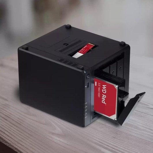 Dispositivo NAS nero con HDD WD Red rossa e SSD su tavolo in legno.