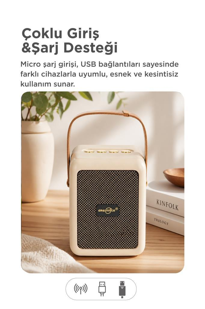 Deri saplı krem rengi hoparlör, kitapların yanında ahşap bir masada duruyor.