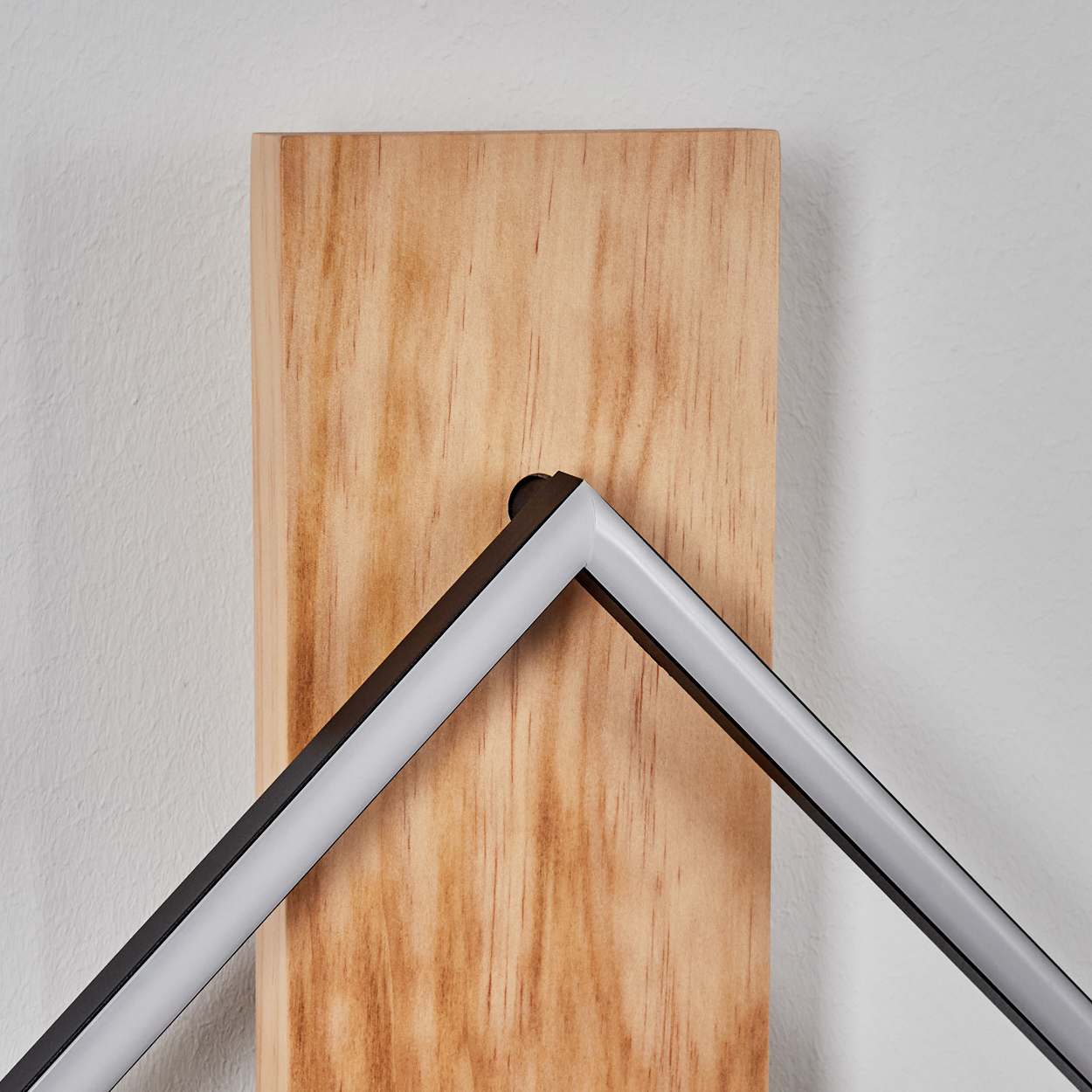 Ein hölzerner Block mit einem L-förmigen Metallrahmen und einer LED-Leiste.