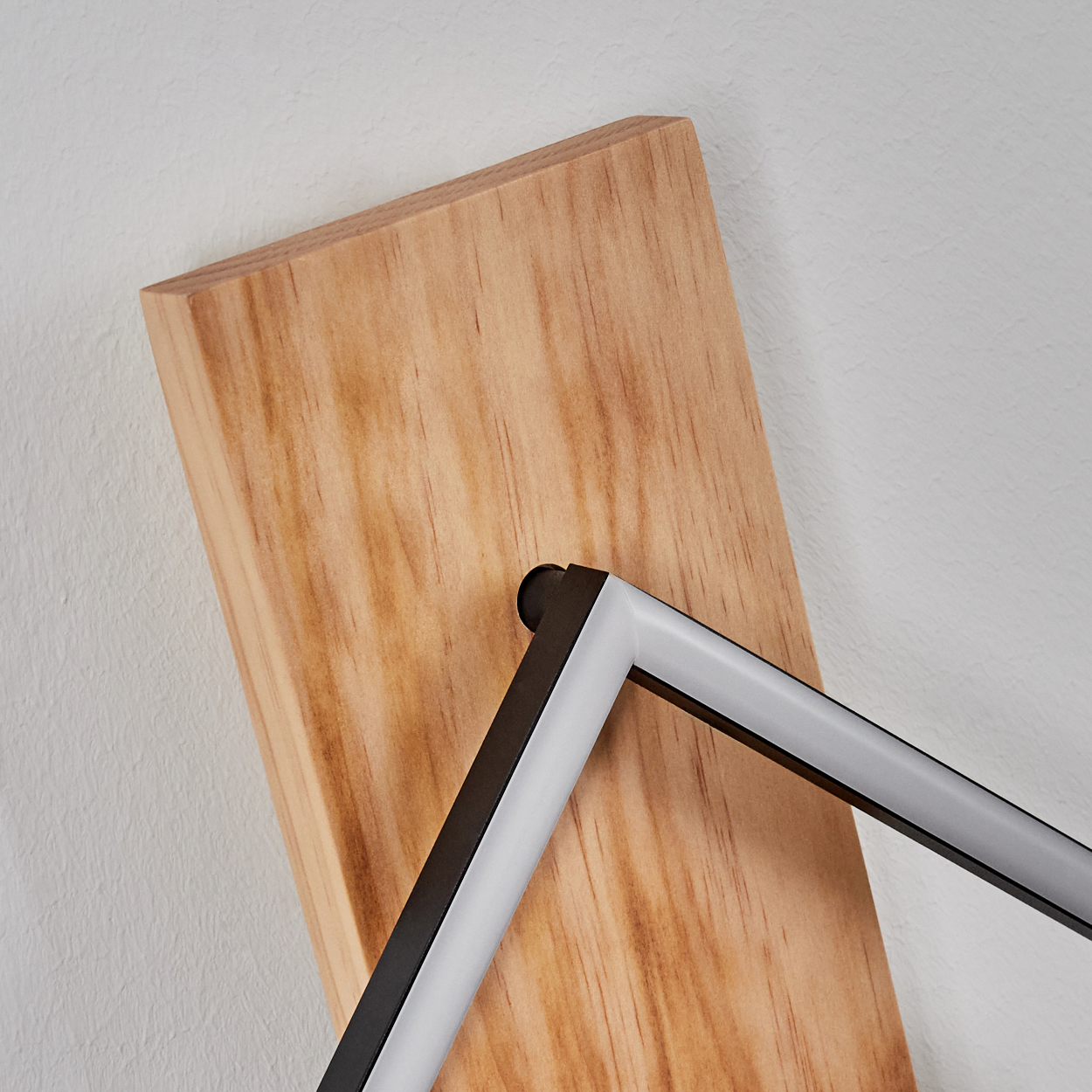 Holzbrett mit schwarzem und weißem Metallrahmen