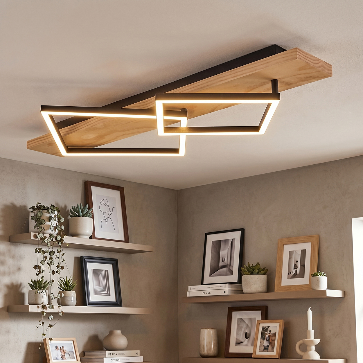 Moderne Deckenleuchte mit Holz und Lichtquadraten über Regalen mit Pflanzen und Bildern.