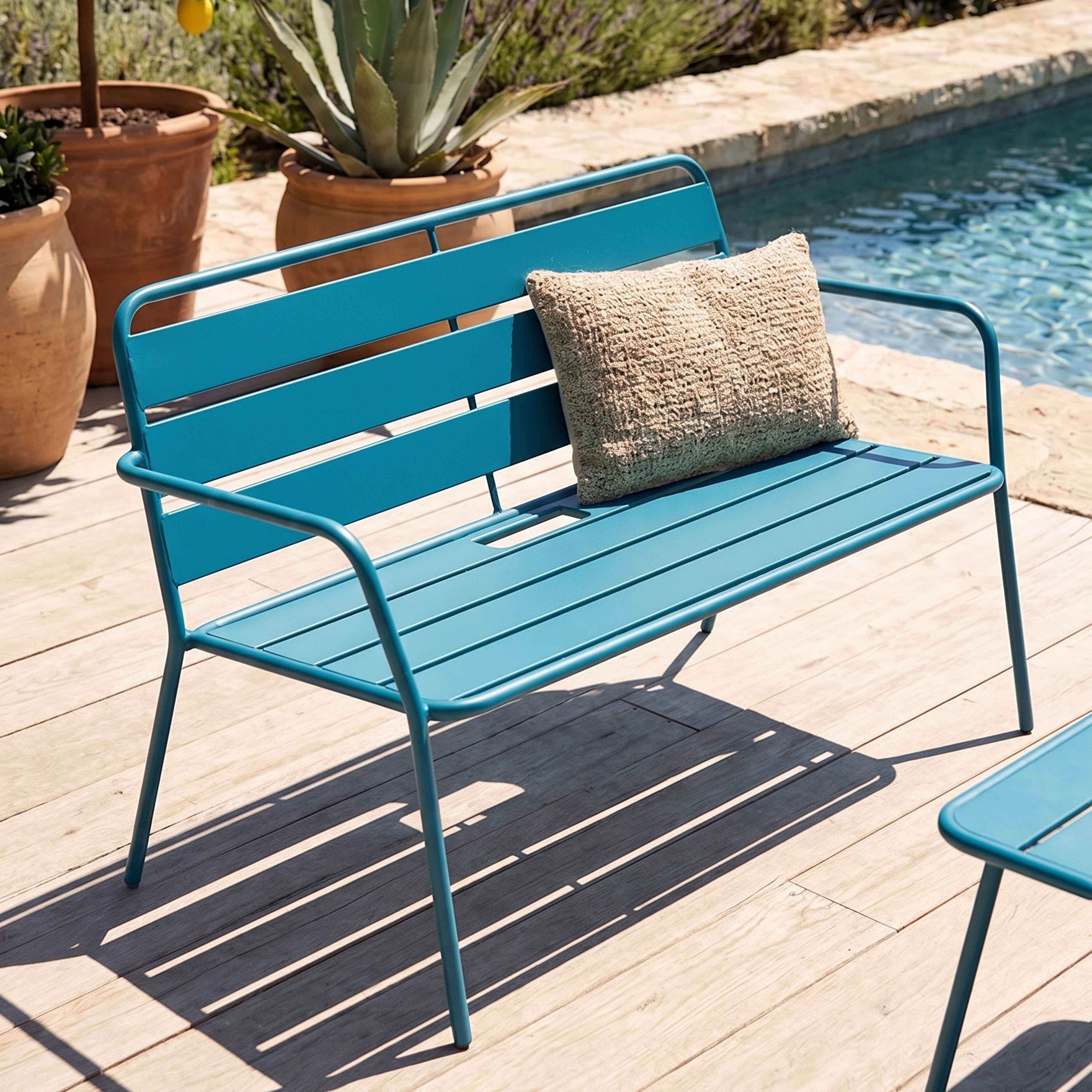 Ein blauer Gartenstuhl mit Kissen steht auf einer Holzterrasse neben einem Pool.