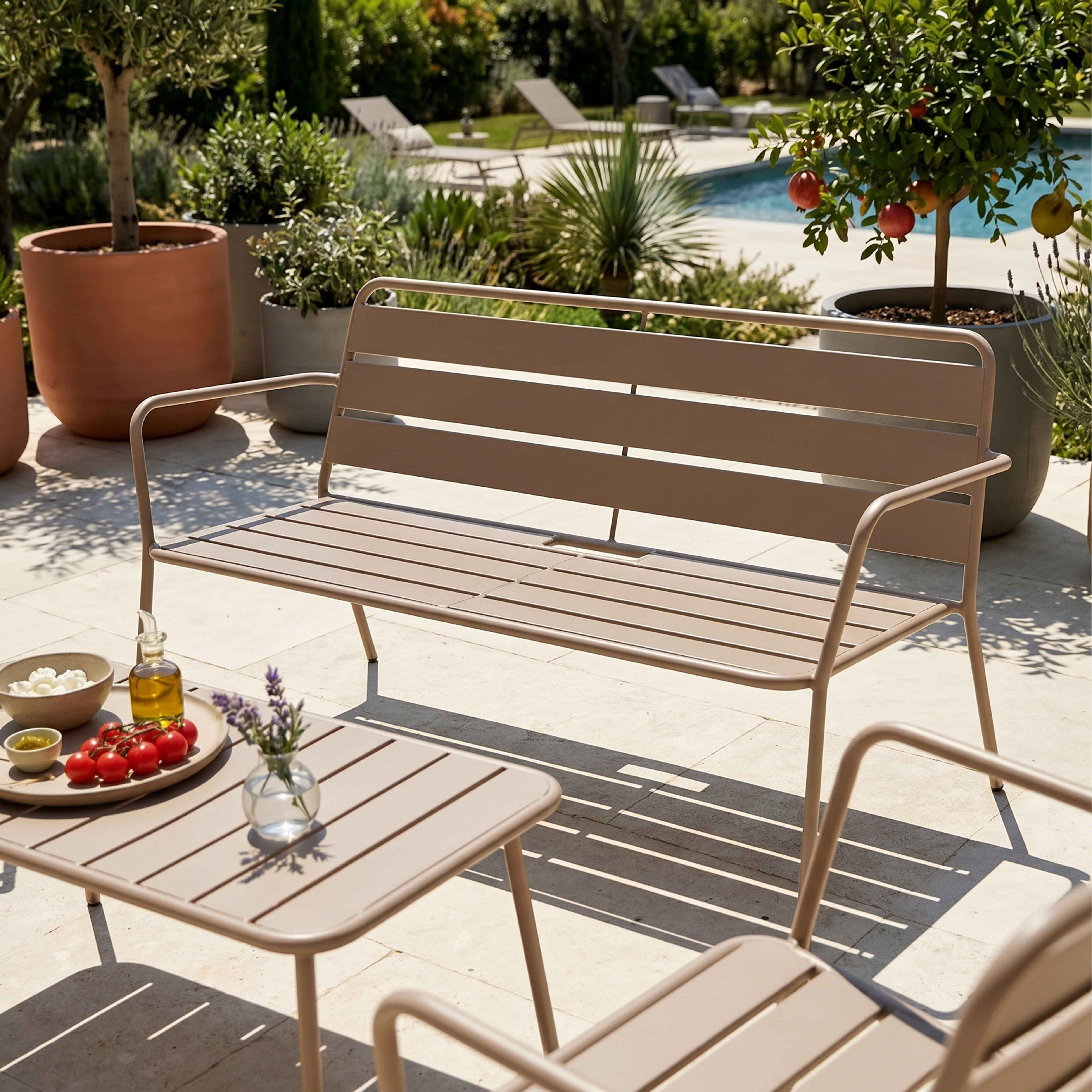 Eine braune Gartenbank und ein Tisch mit Essen stehen auf einer Terrasse neben einem Pool.