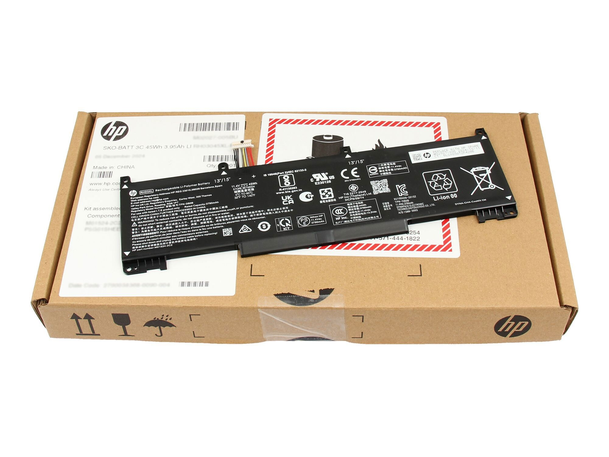 HP Laptop-Akku in einer geöffneten Pappschachtel, mit Aufklebern und Warnhinweisen.