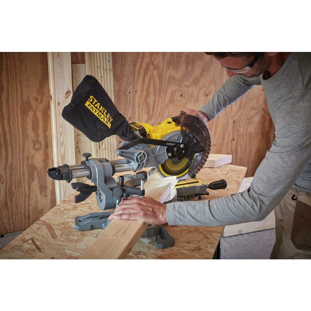 Mann schneidet Holz mit einer gelben Stanley Fatmax Gehrungssäge in einer Werkstatt.