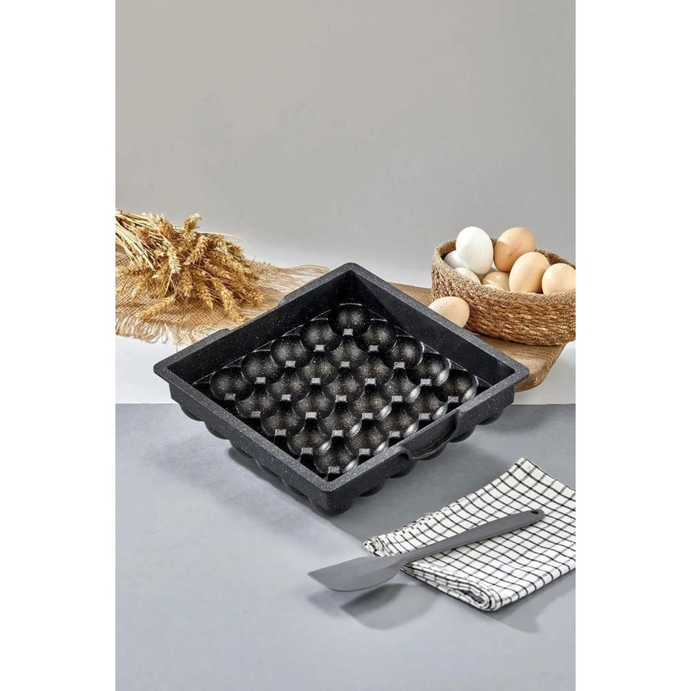 30 oyuklu siyah yumurtalık masanın üzerinde duruyor. Yanında sepette yumurtalar var.