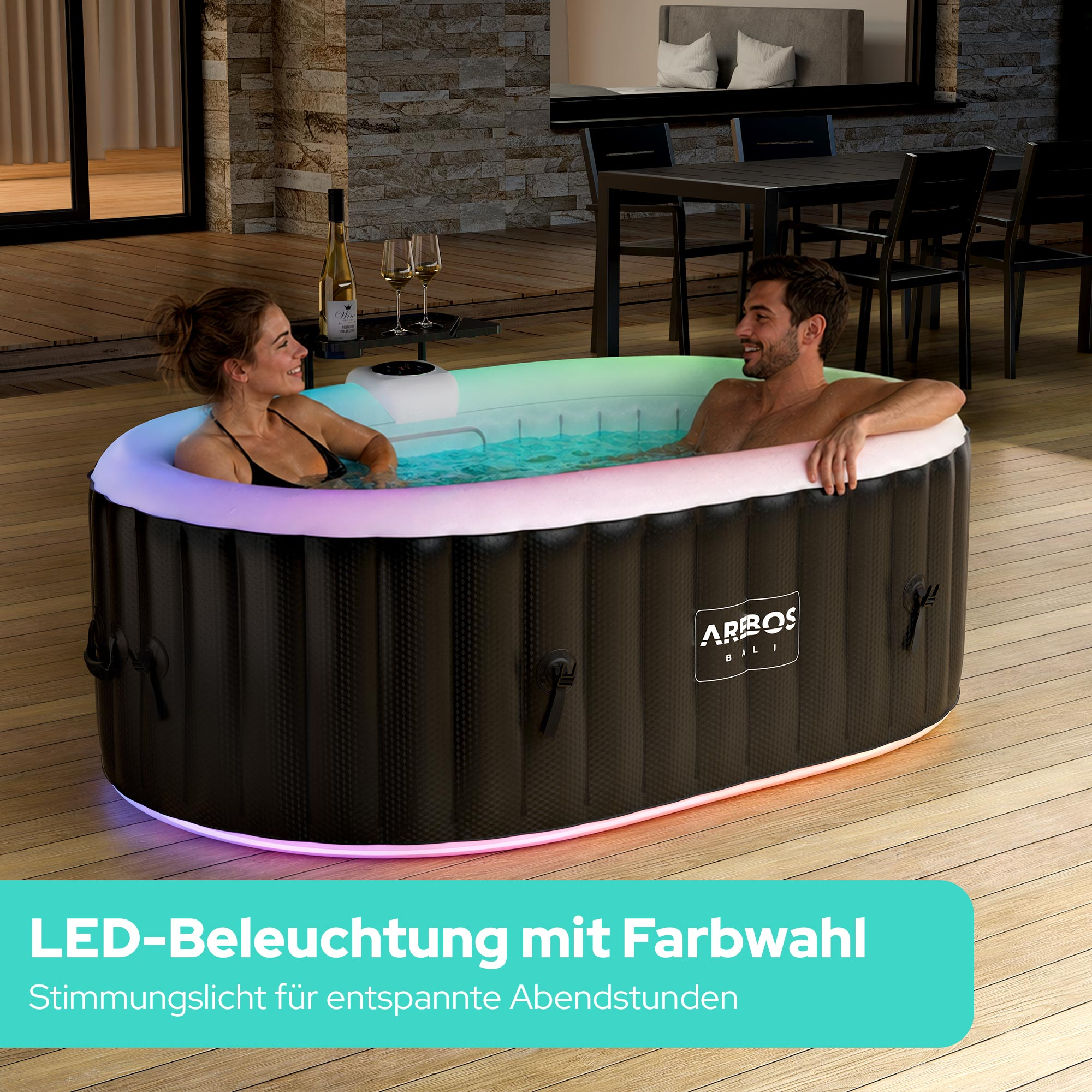 Mann und Frau im beleuchteten Whirlpool auf einer Holzterrasse mit Möbeln.
