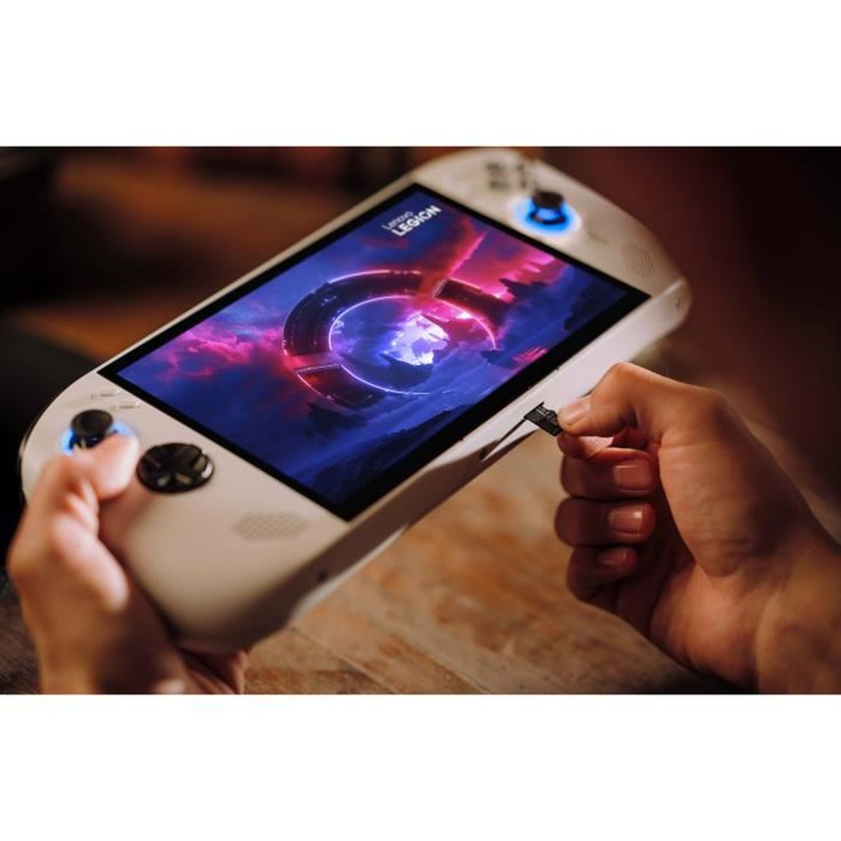 Eine weiße Hand hält einen Handheld-Gaming-PC, während sie eine Speicherkarte einsteckt.