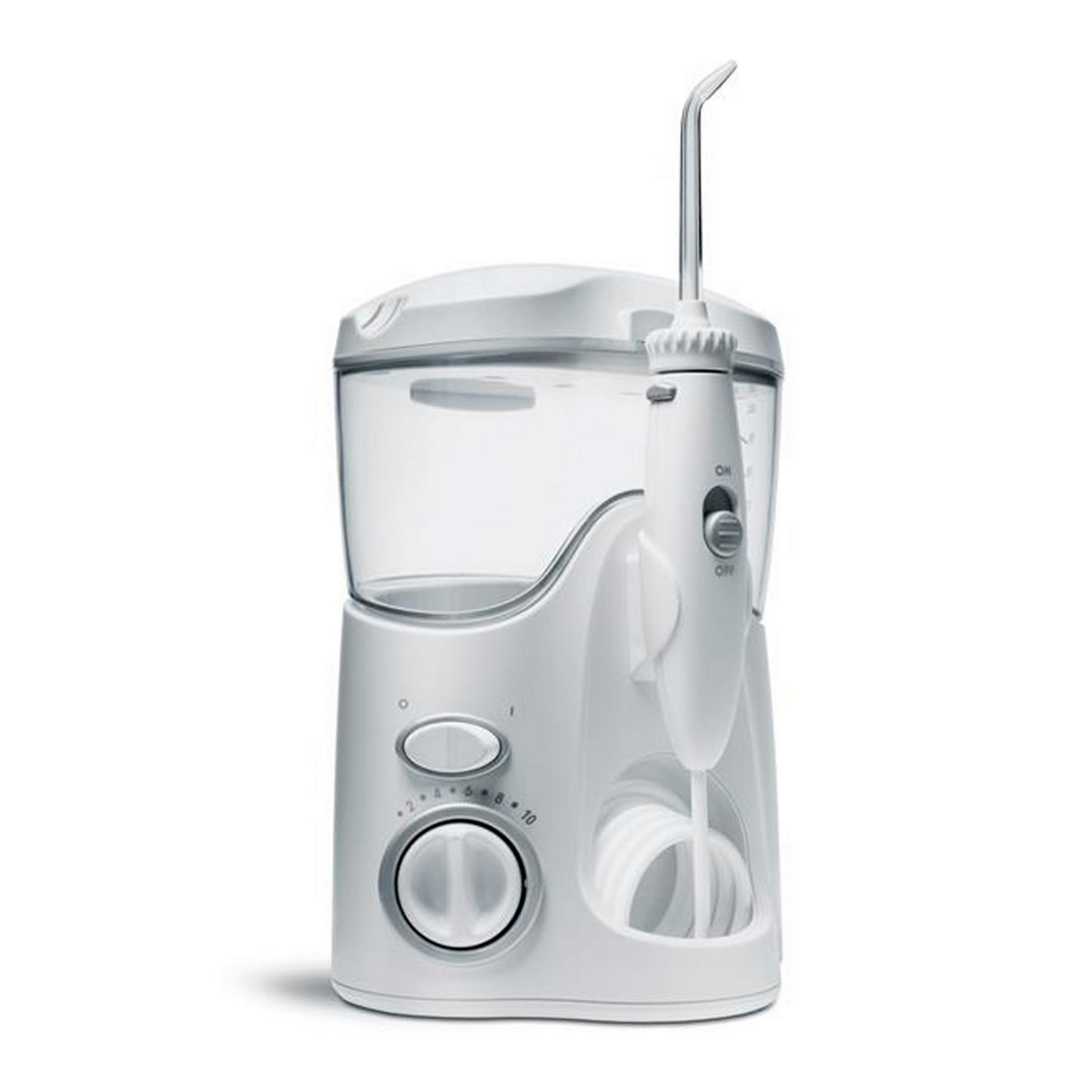 Un irrigador bucal eléctrico blanco con depósito transparente y soporte para manguera.