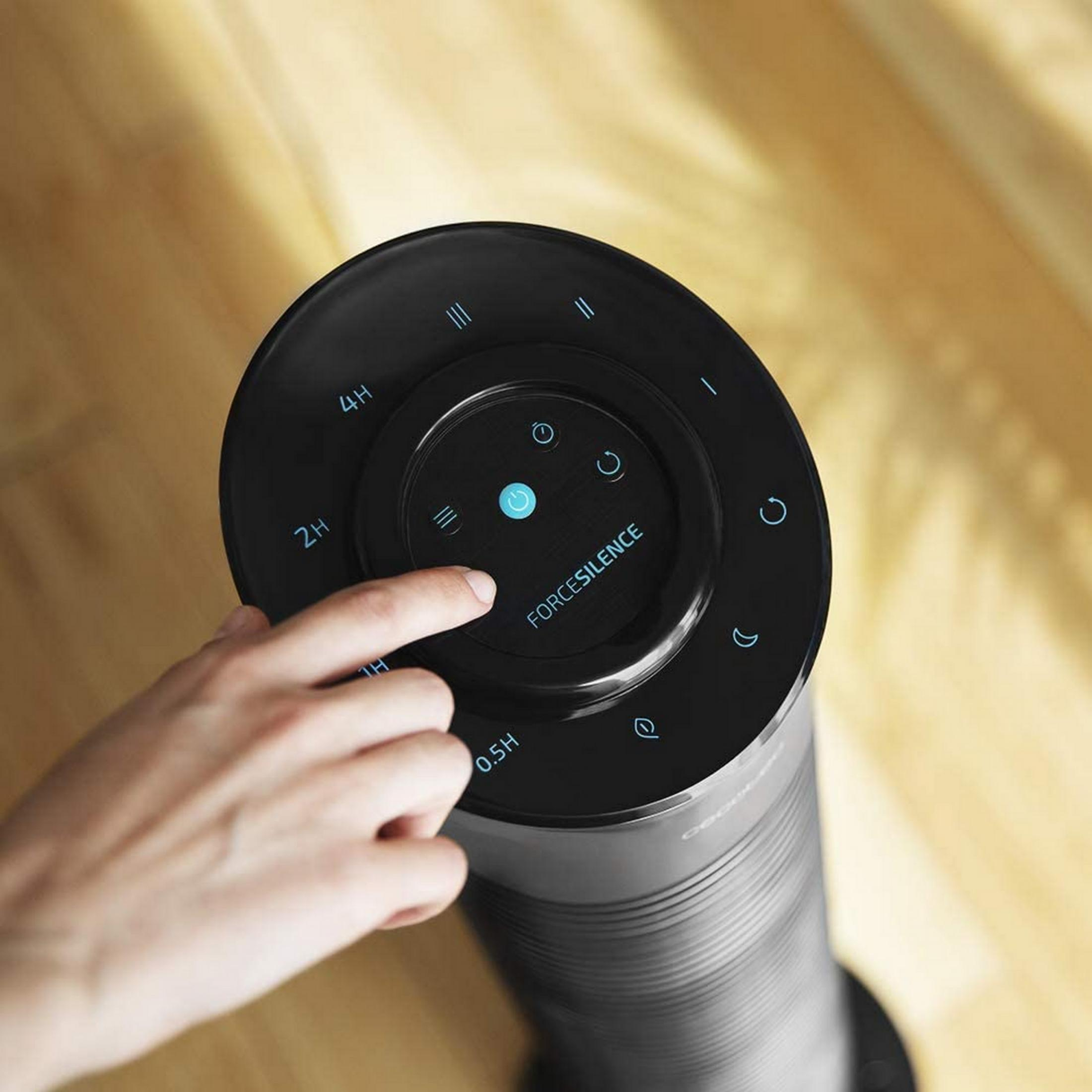 Una mano presiona un botón en una pantalla de ventilador negra con iconos azules.