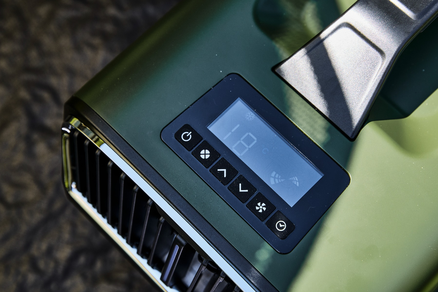 Dispositivo verde scuro con display digitale e controlli. Prese d'aria visibili.