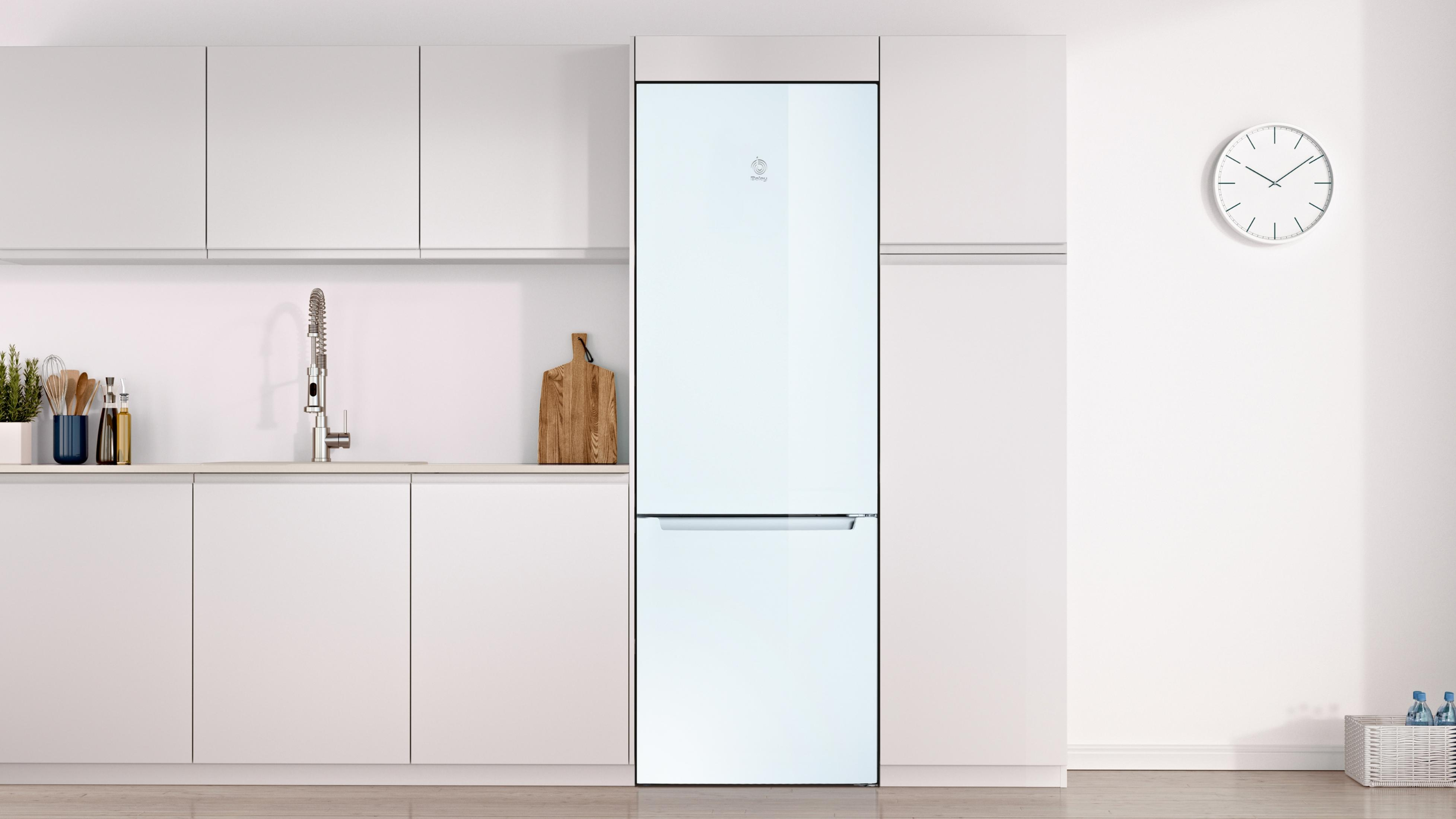 Cocina moderna blanca con frigorífico, fregadero y reloj de pared.