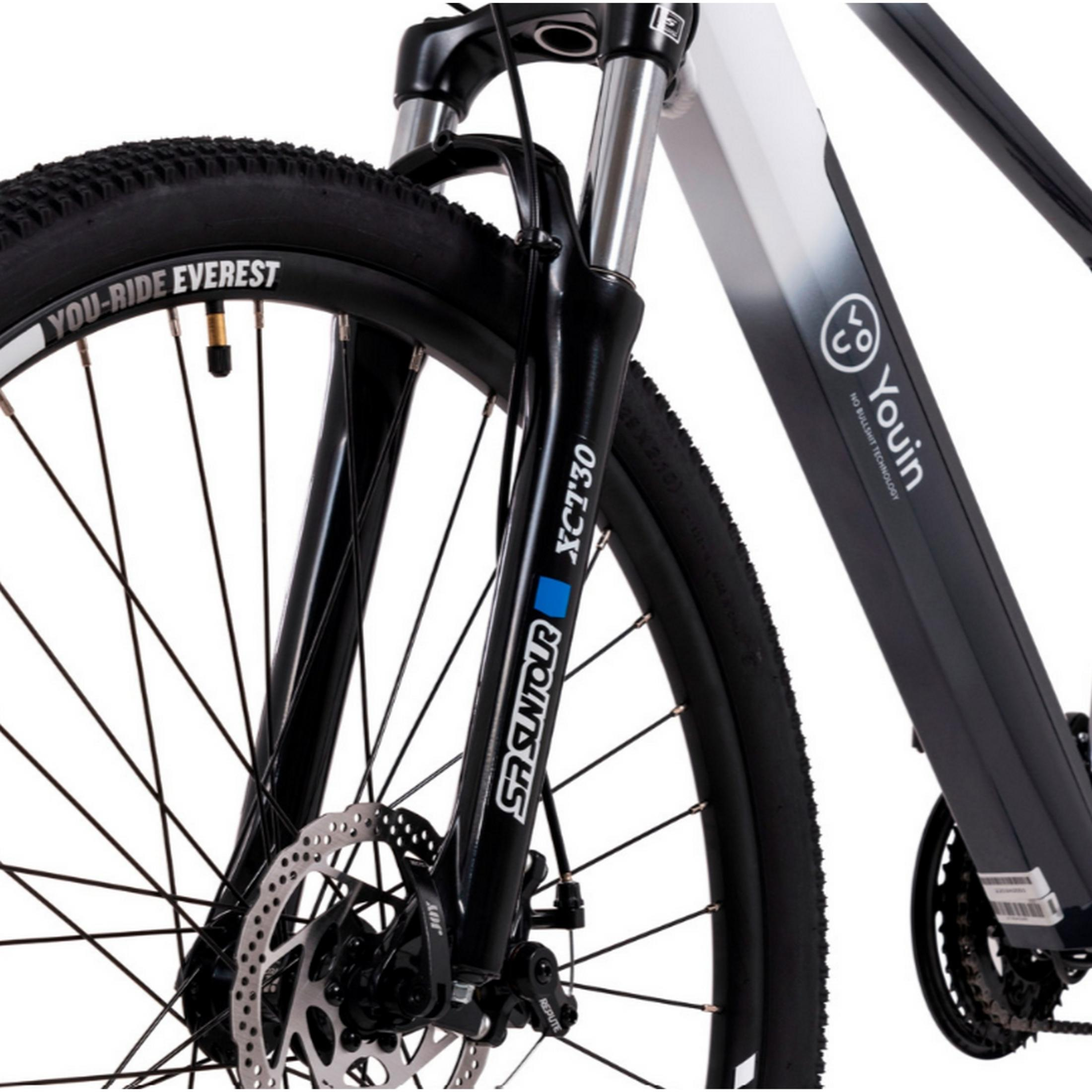 Vista frontal de una bicicleta negra con freno de disco y horquilla de suspensión.