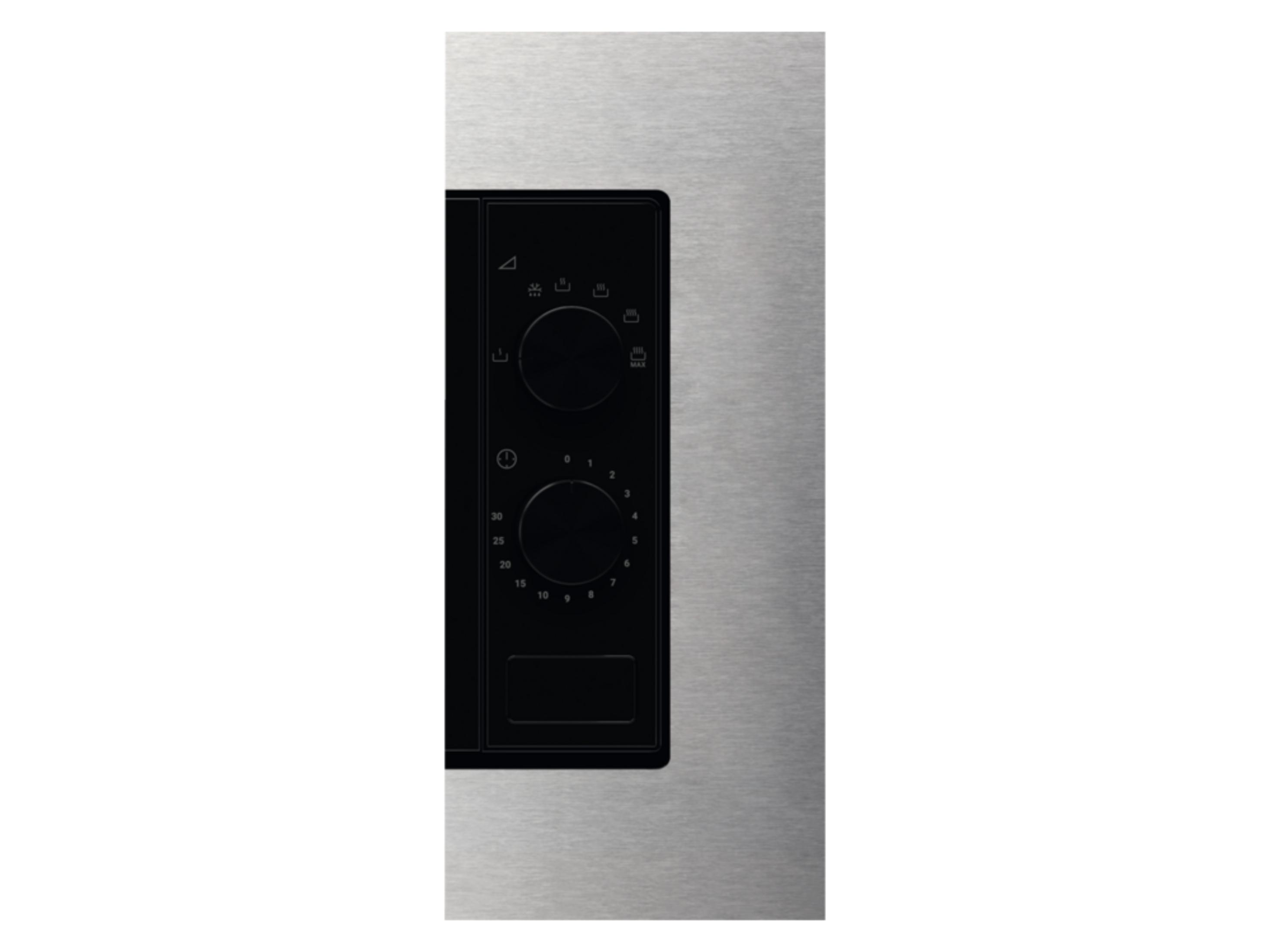 Primer plano de un microondas plateado con panel de control y diales negros.