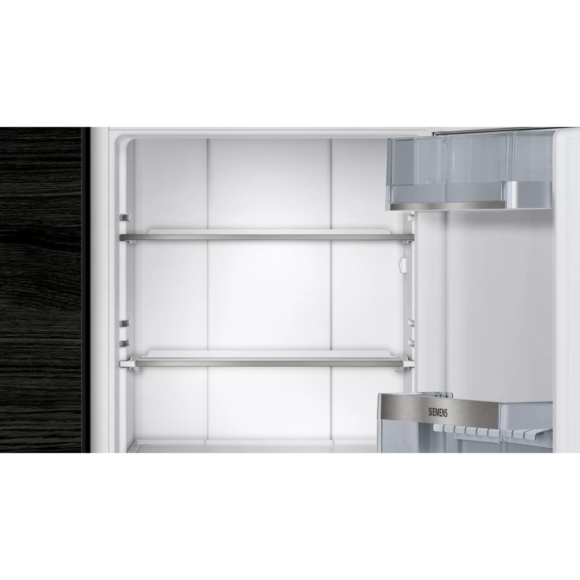 Un refrigerador vacío con paredes blancas, dos estantes de cristal y un cajón Siemens.