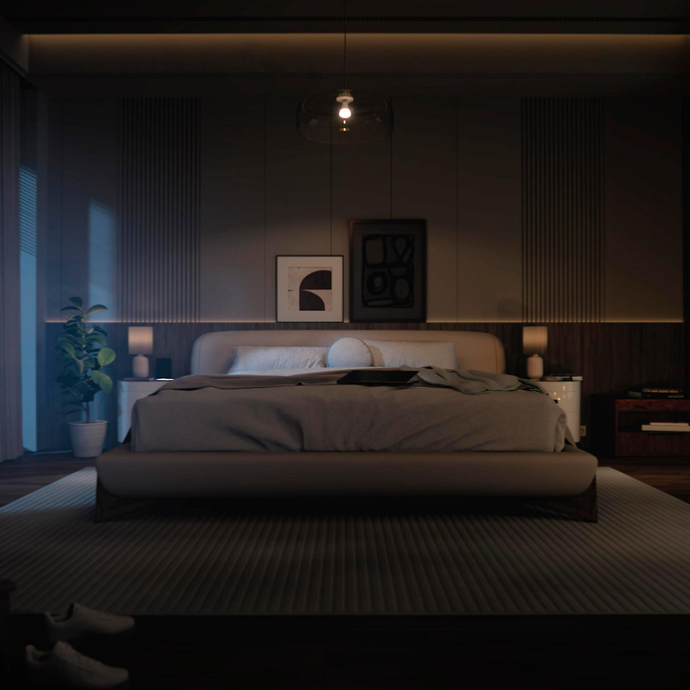 Una camera da letto buia con un grande letto, comodini, arte e una pianta.