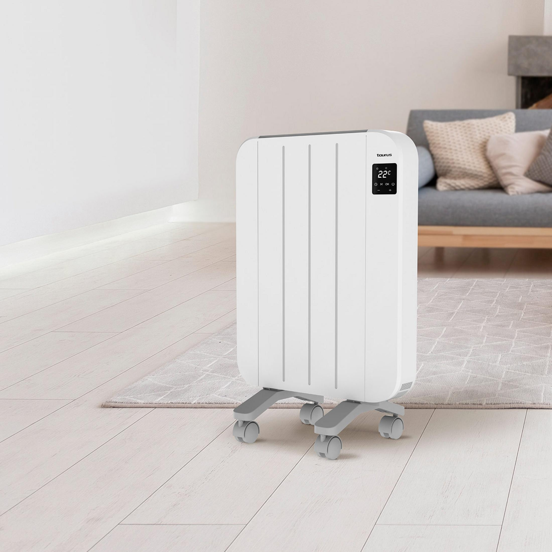 Un radiador blanco con ruedas sobre suelo de madera junto a un sofá.