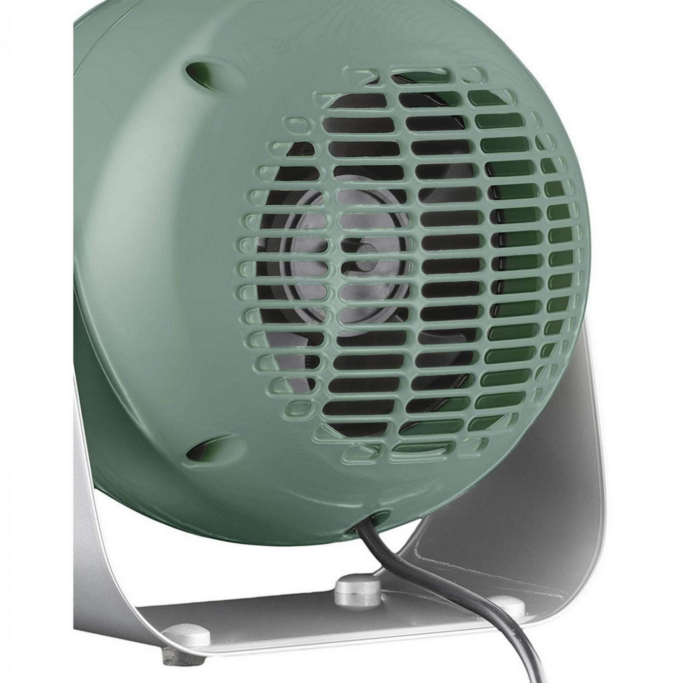 Primo piano di un ventilatore verde con base argentata e cavo nero. La ventola ha una griglia a lamelle.