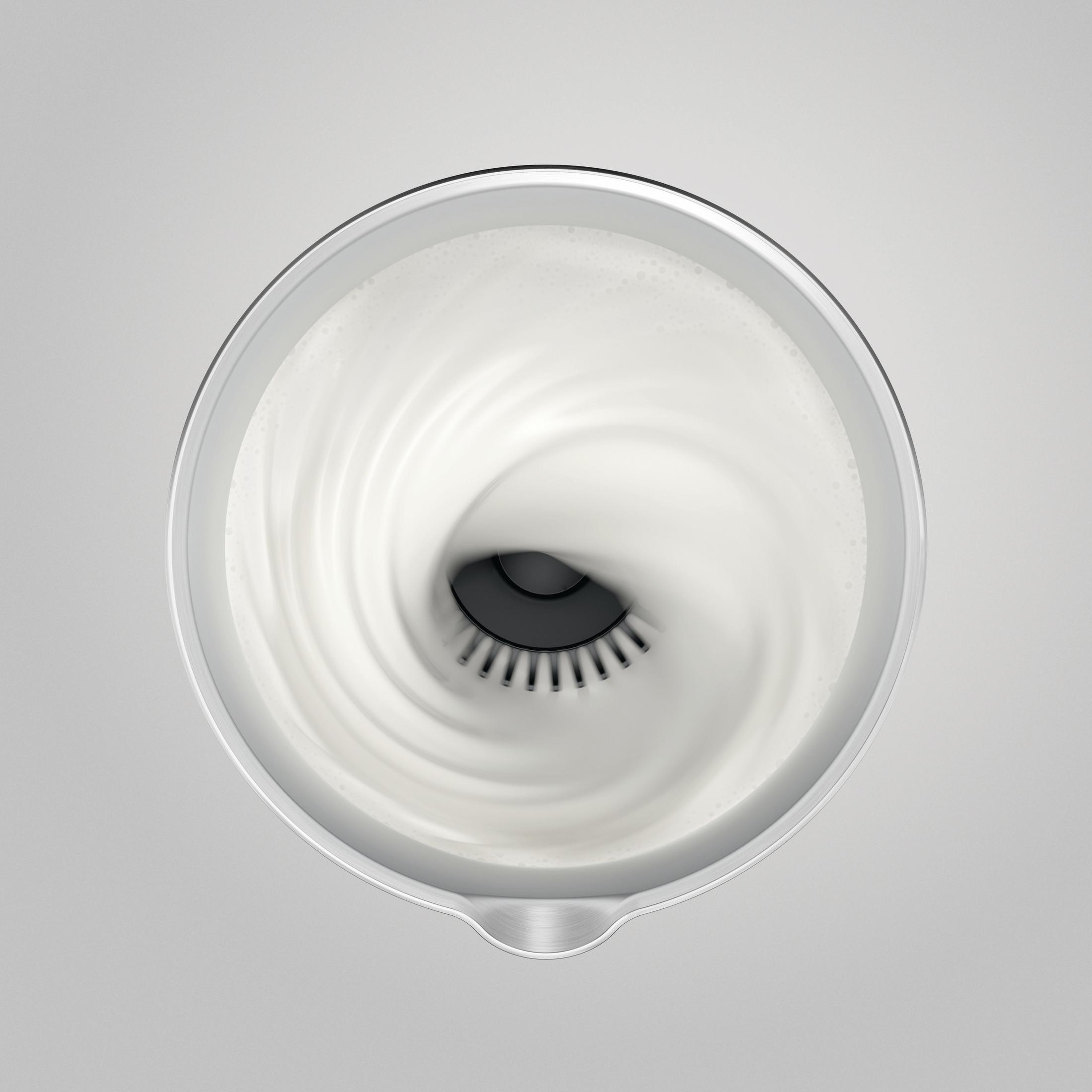 Una frusta mescola liquido bianco in un contenitore metallico, creando un vortice.