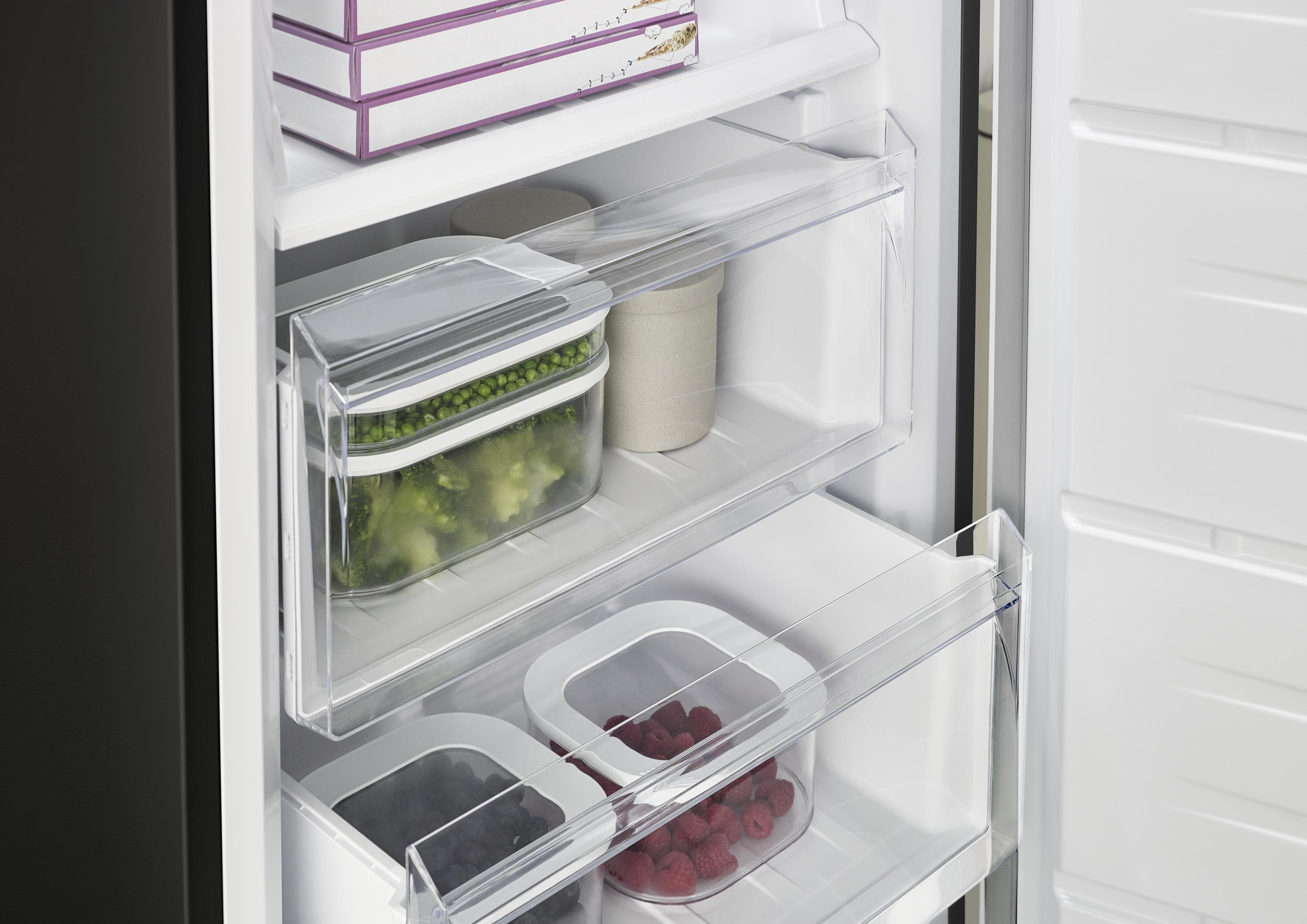 Gefrierschrank mit gefrorenem Brokkoli, Erbsen, Beeren und Packungen.
