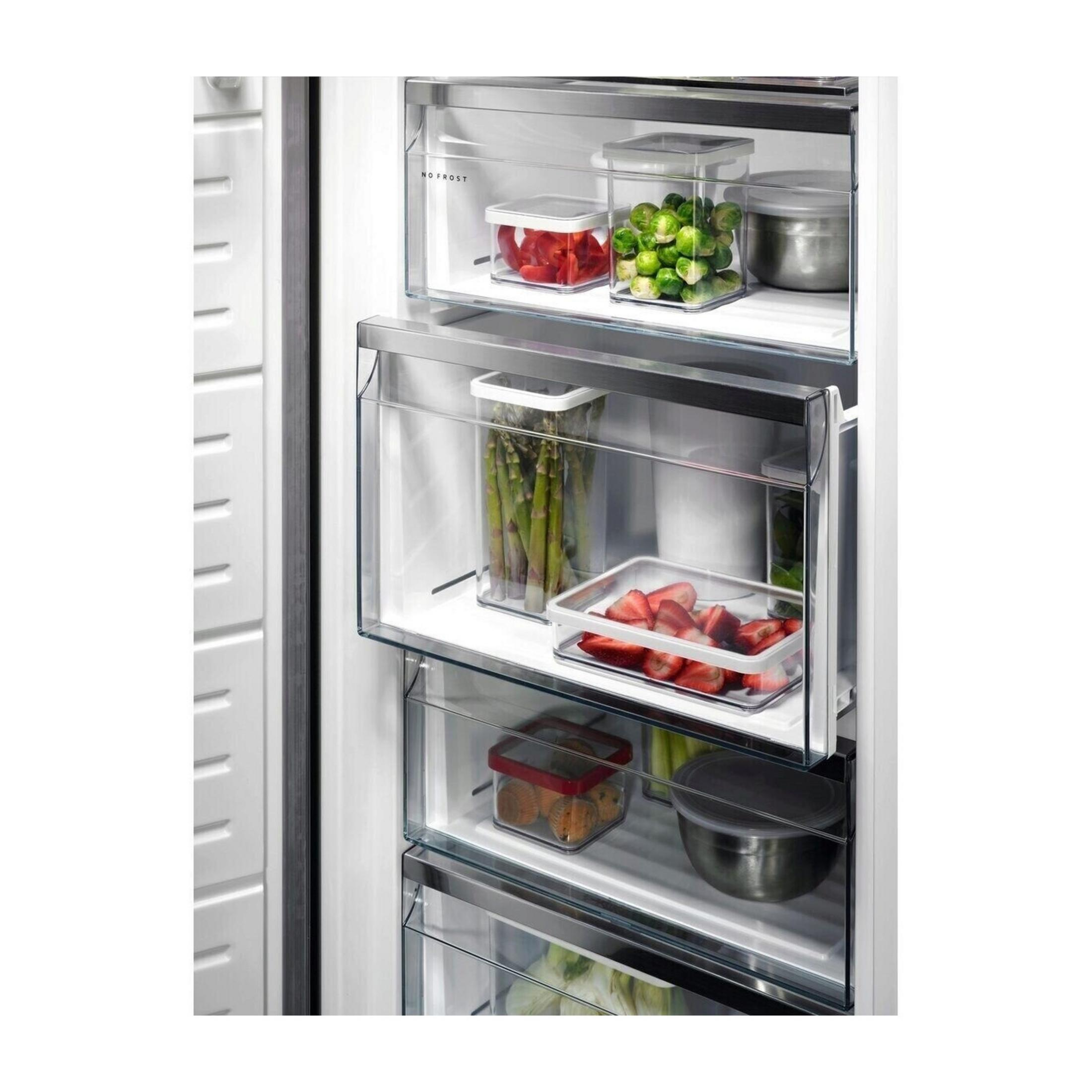 Cajones de refrigerador con alimentos: pimientos, coles de Bruselas, espárragos, fresas, magdalenas.
