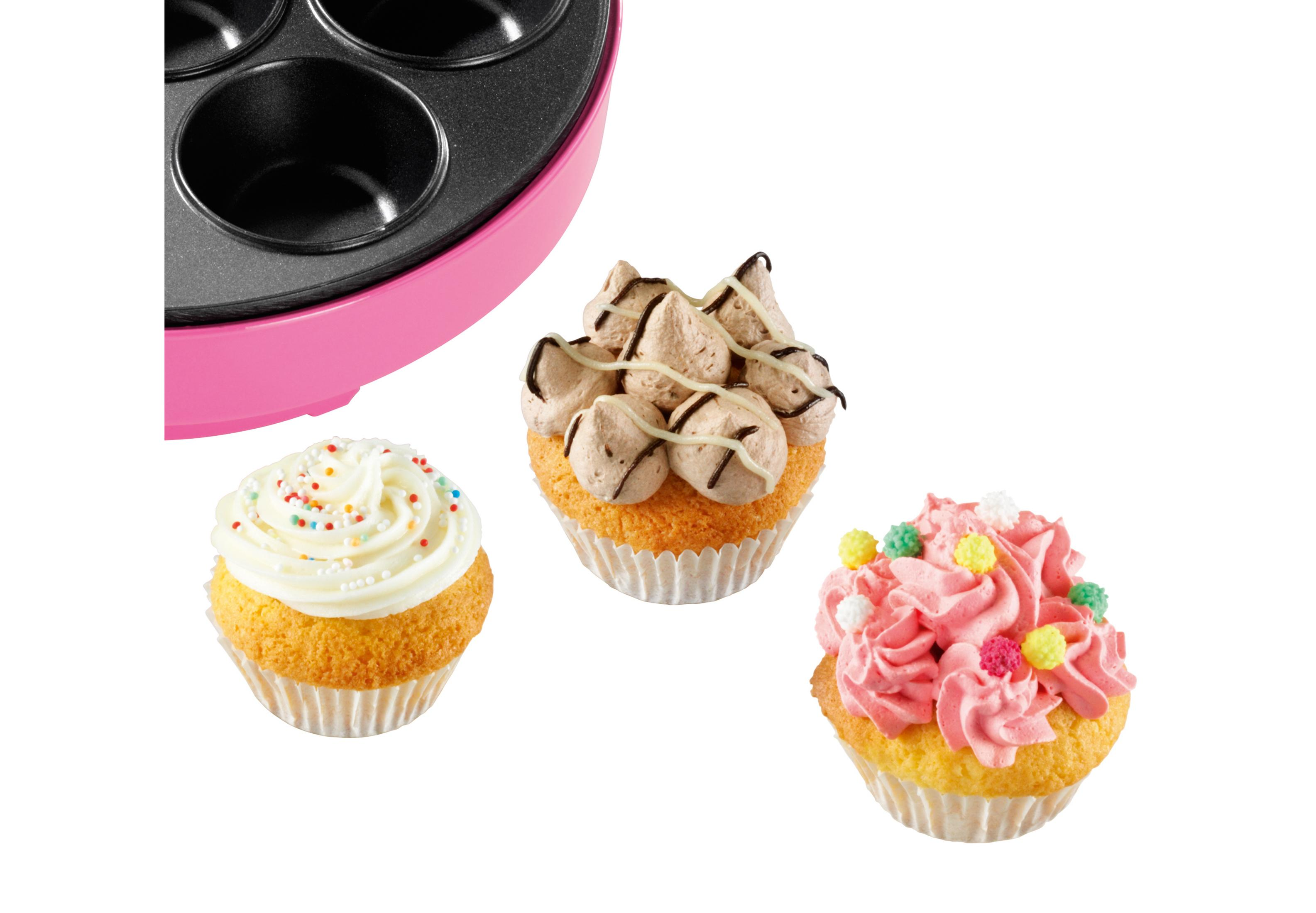 Una macchina per cupcake rosa con tre cupcake decorati.