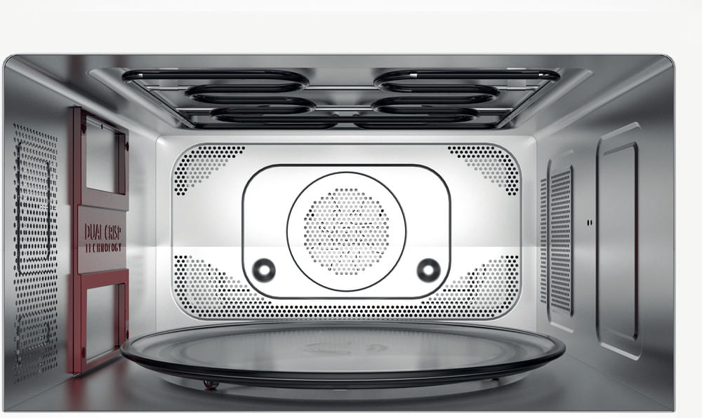 Vista interna di un forno a microonde con resistenze, ventola e piatto girevole.