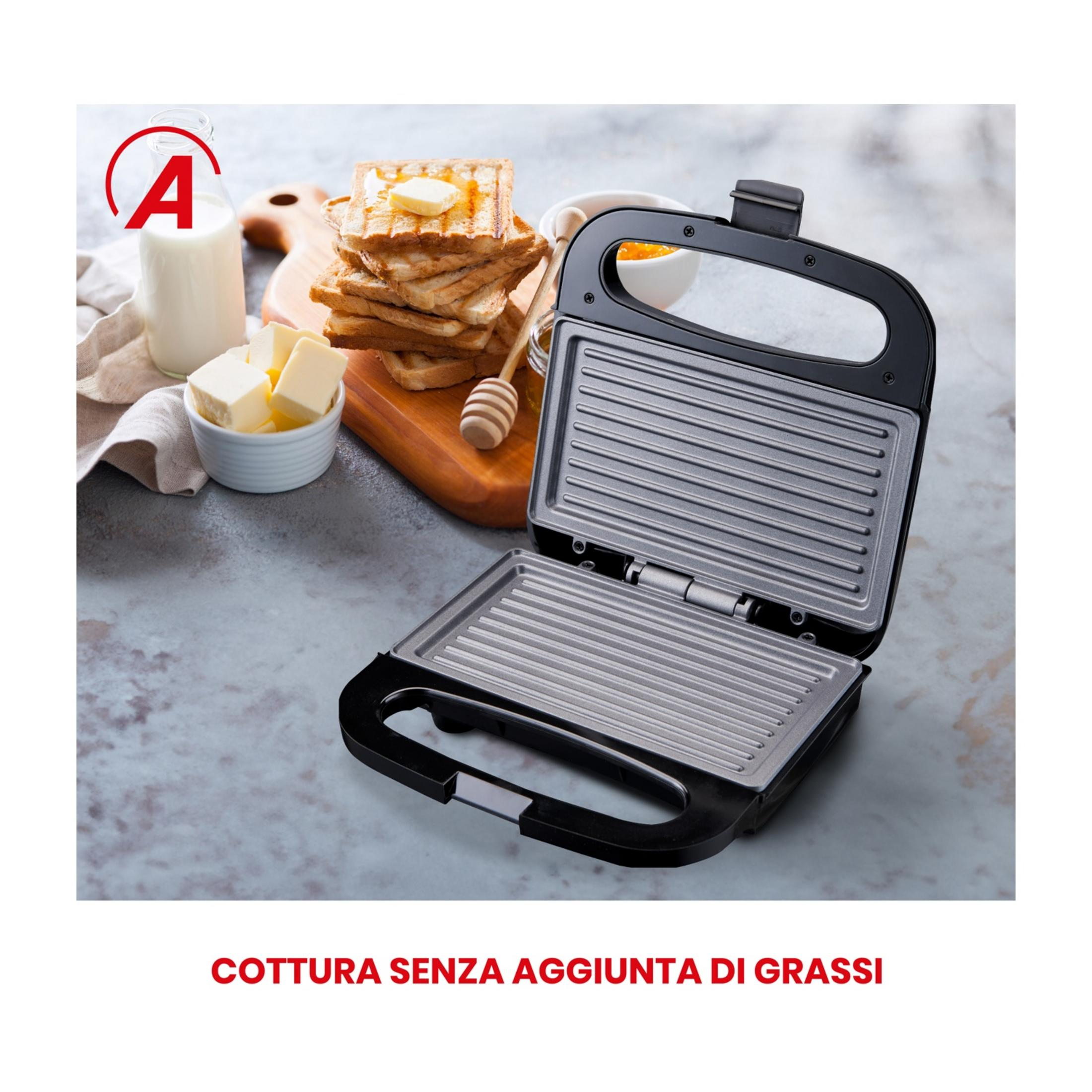 Una parrilla de contacto abierta con tostadas, mantequilla, leche y mermelada al lado.