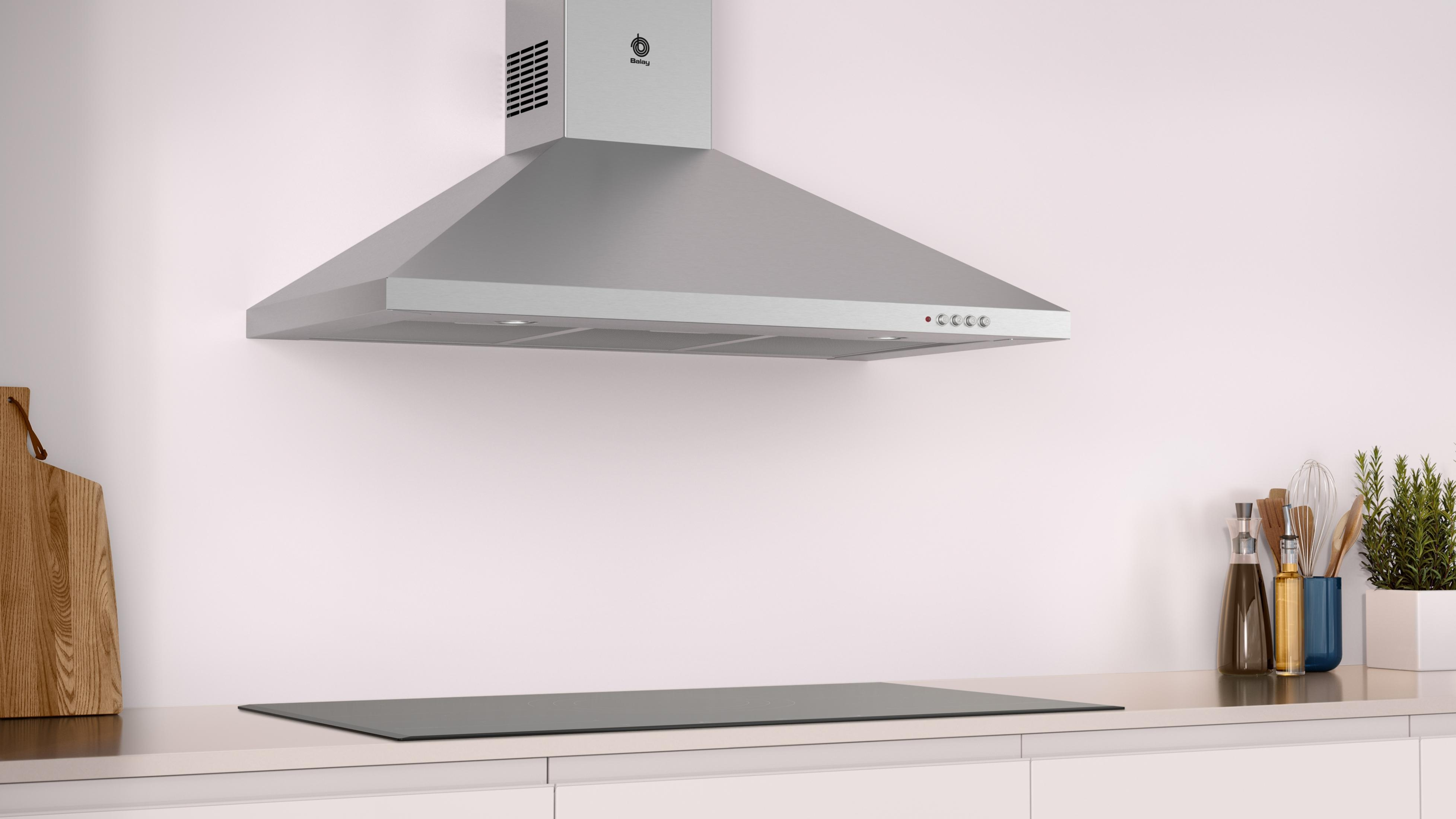 Una campana extractora de acero inoxidable sobre una placa de cocina en una cocina moderna.
