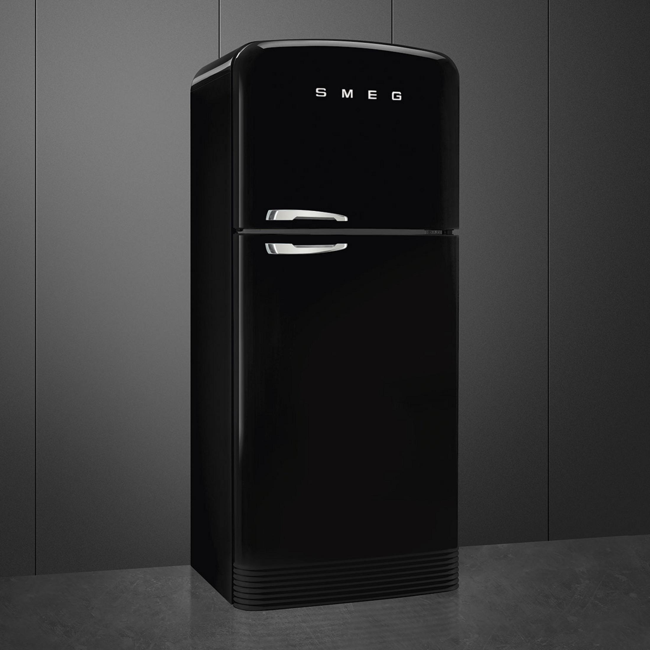 Un refrigerador SMEG negro brillante con tiradores cromados sobre fondo gris.