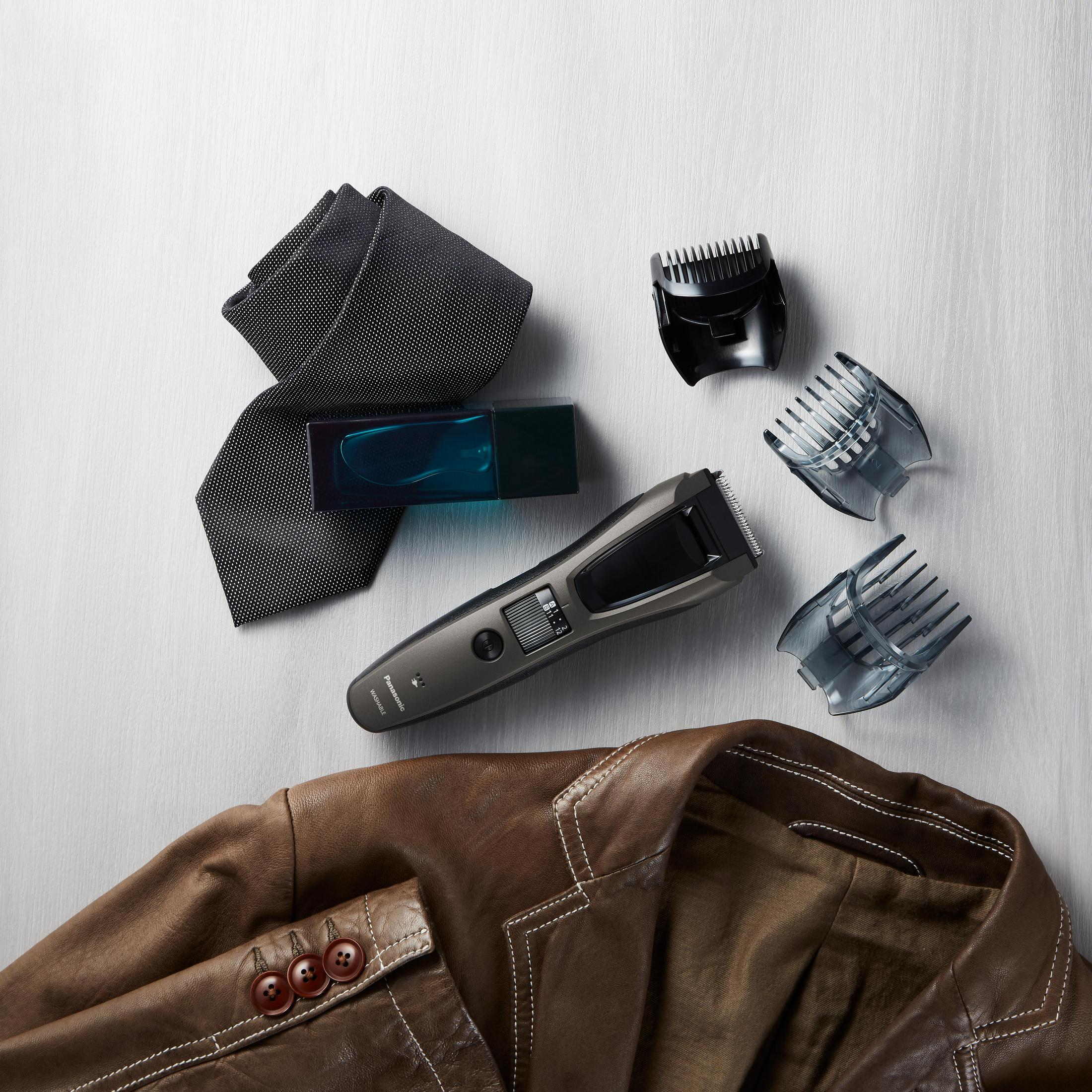 Una giacca di pelle marrone, cravatta nera, colonia e tagliacapelli con accessori.
