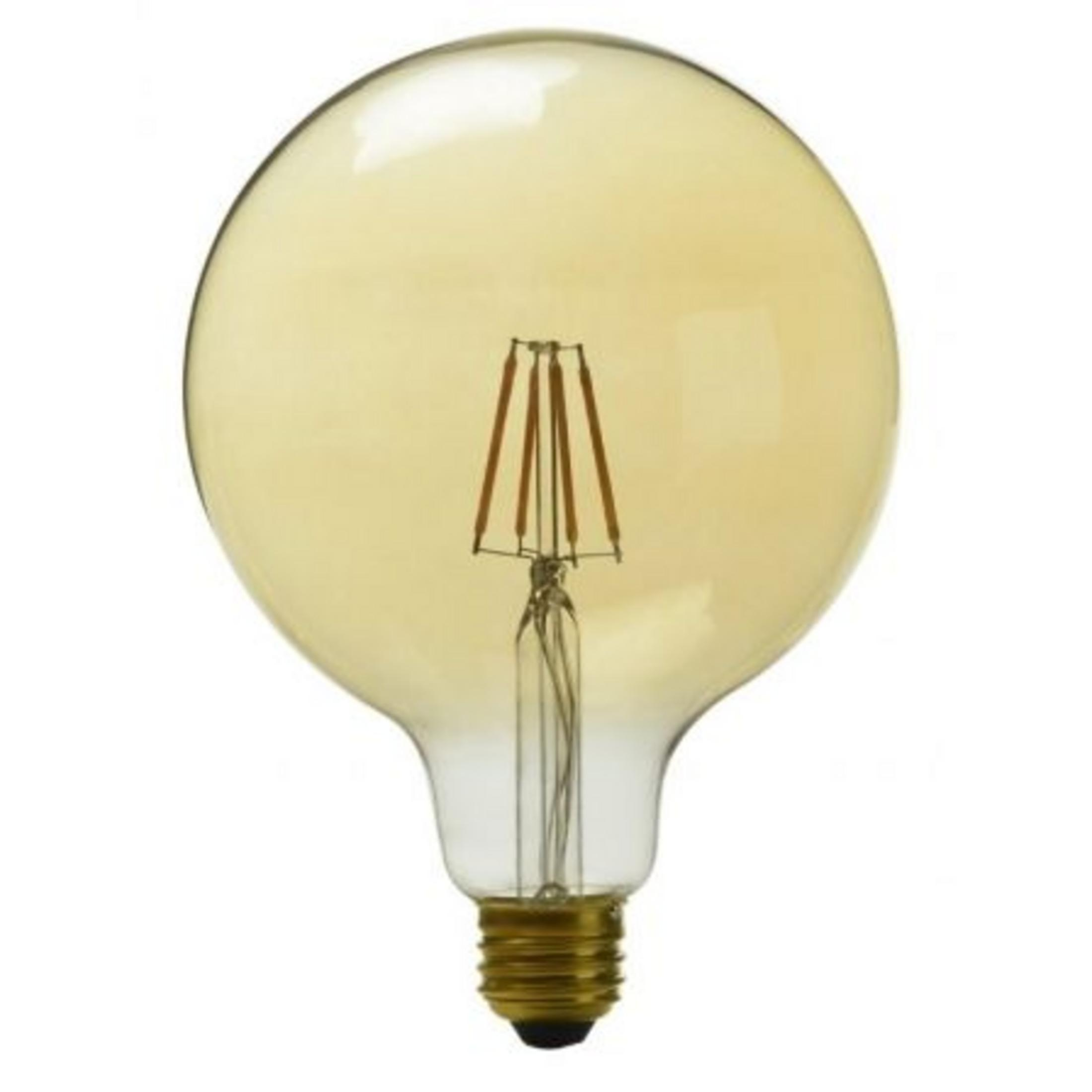 Una grande lampadina color ambra con filamenti visibili e base in ottone.