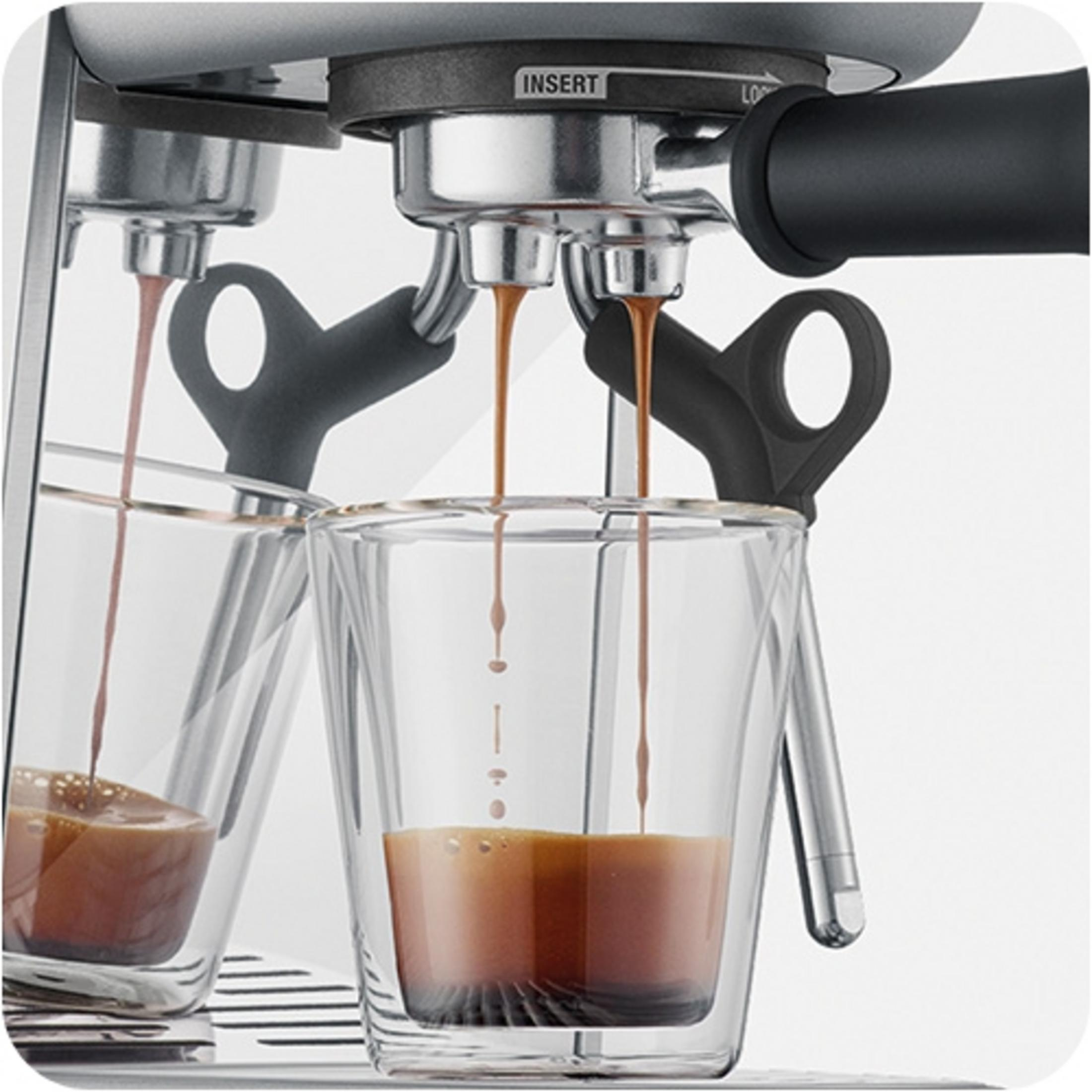 Espressomaschine brüht zwei Tassen Kaffee in transparente Gläser.